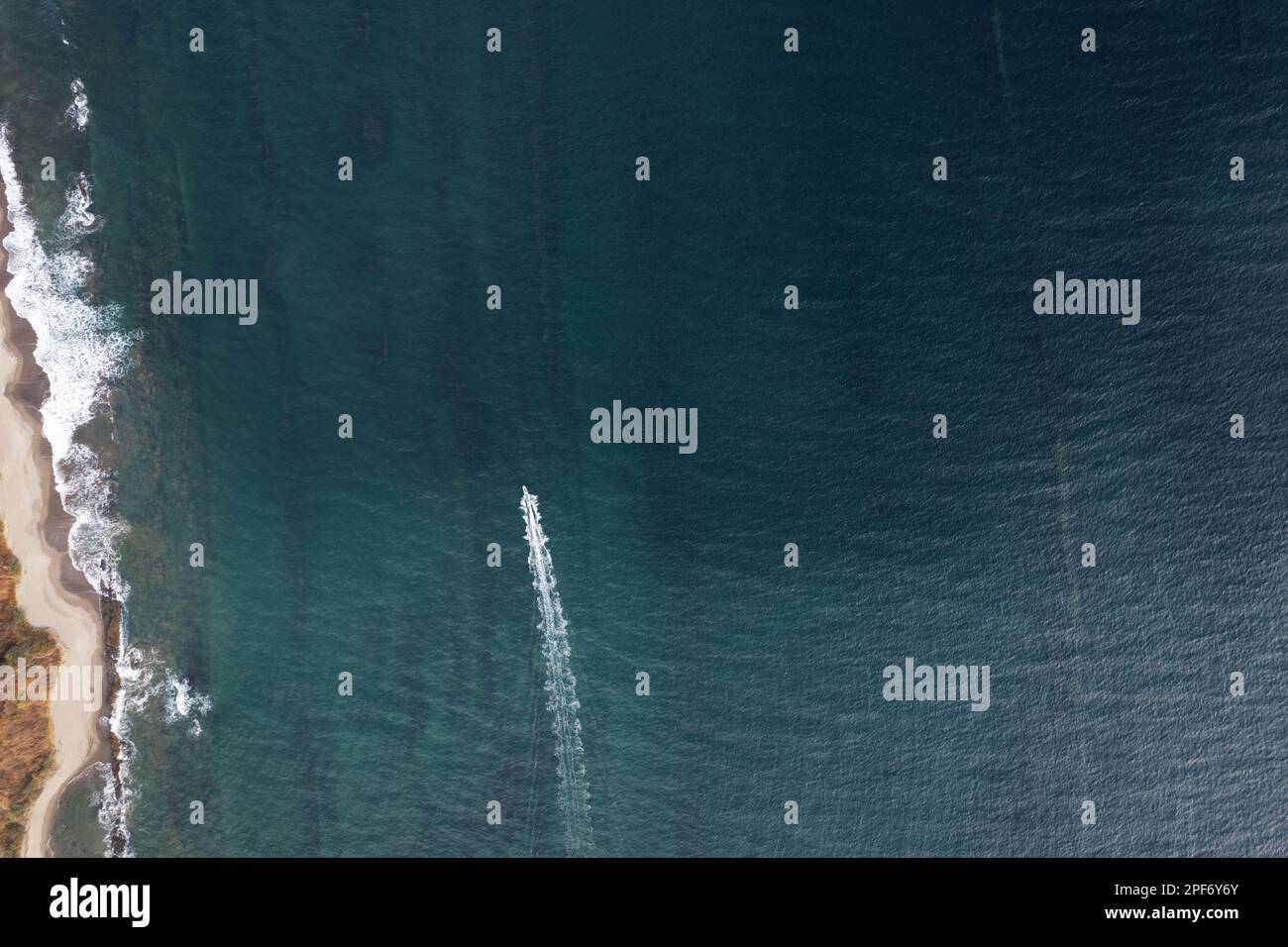 Una piccola barca che si sposta velocemente vicino alla spiaggia sopra la vista dall'alto Foto Stock