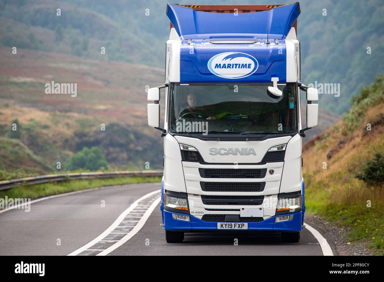 Un camion Scania del gruppo marittimo che tira un rimorchio con un contenitore di spedizione si dirige verso il A628 Woodhead Pass nello Yorkshire Foto Stock