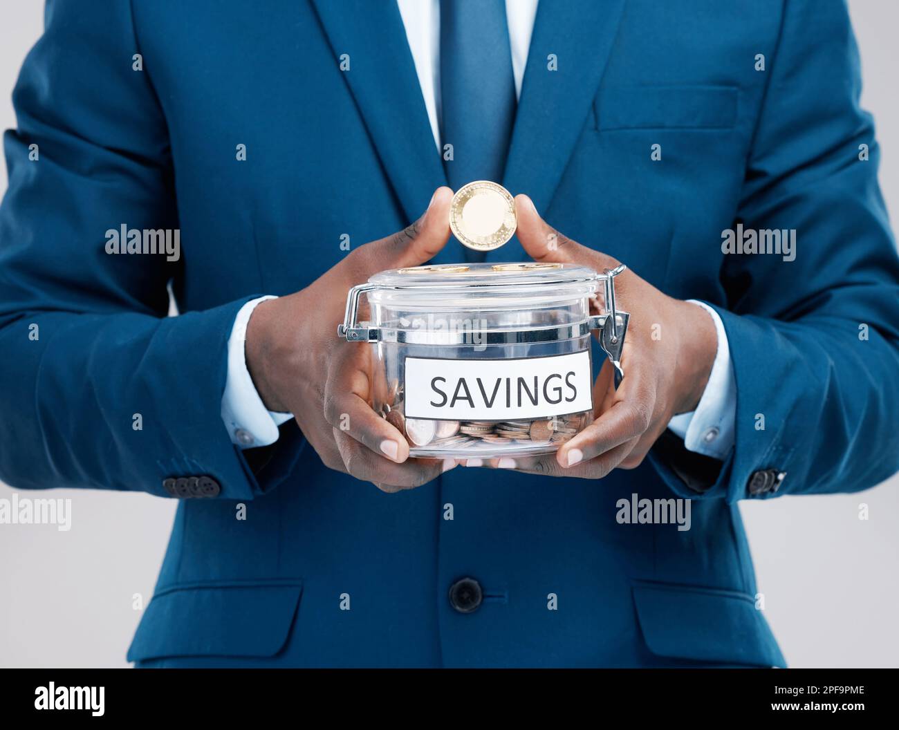 Non andare rotto cercando di essere ricco. Studio shot di un uomo d'affari che tiene un vaso pieno di bitcoins con la parola risparmio su di esso su uno sfondo grigio. Foto Stock