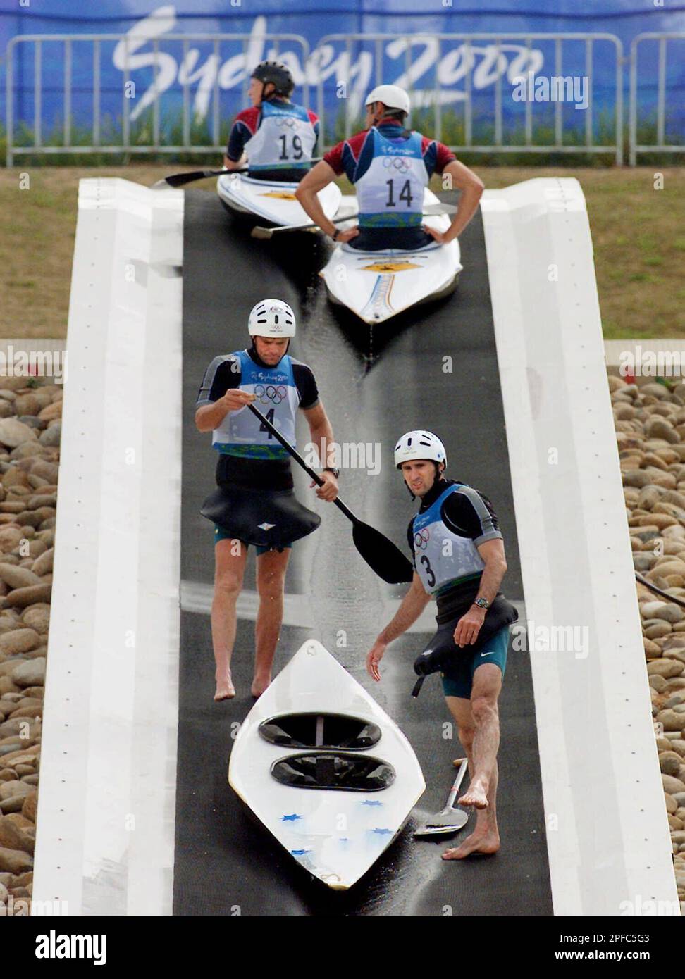 Australian slalom canoeists Andrew Farrance (4) and Kai Swoboda (3) ride the conveyor belt up the course during C-2 training in the slalom at the Penrith Whitewater Stadium in Penrith, Australia, Thursday, Sept. 14, 2000. The Olympic course is manmade. (AP Photo/Kevin Frayer) Foto Stock
