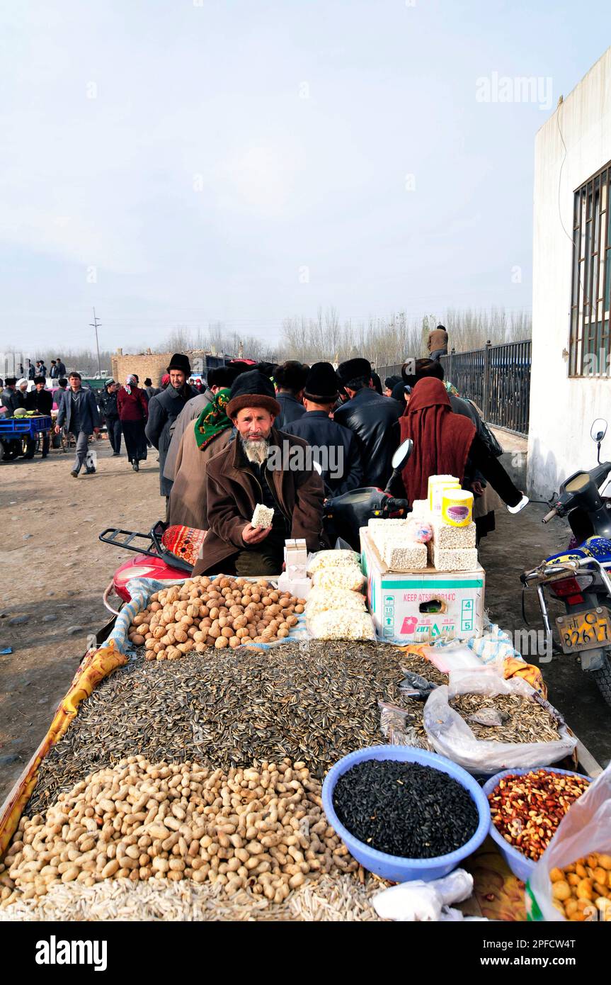 Un venditore di frutta secca e noci in un grande mercato settimanale nella periferia di Kashgar, Xinjiang, Cina. Foto Stock