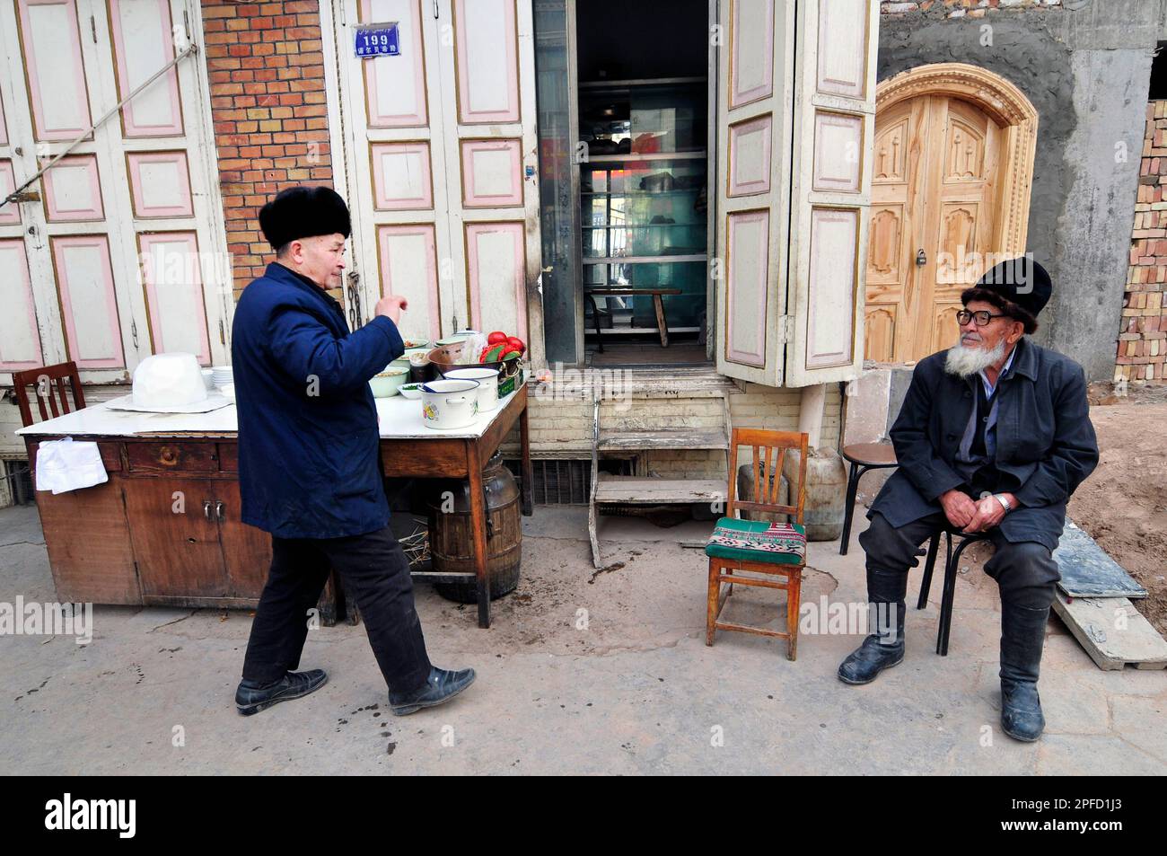 Uomini di Uyghur seduti in un negozio nella città vecchia di Kashgar, Xinjiang, Cina. Foto Stock