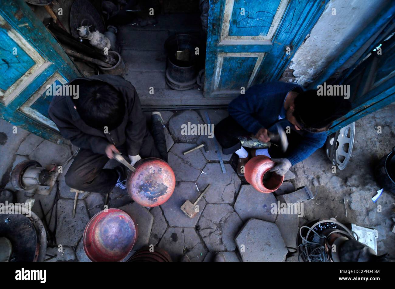 Un fabbro di Uyghur che lavora su pentole tradizionali nella città vecchia di Kashgar, Xinjiang, Cina. Foto Stock