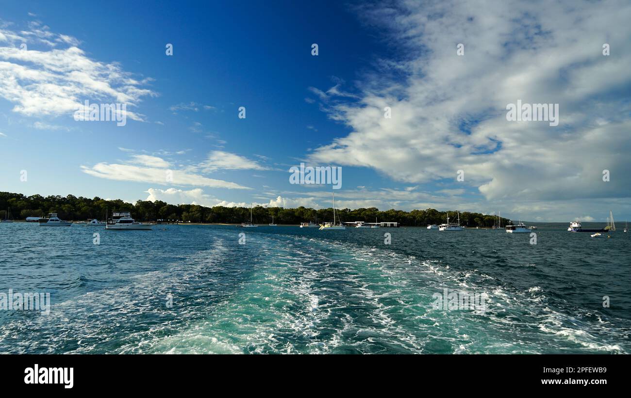 Acqua turbolenta sulla scia del traghetto veicolare con Coochiemudlo Island in lontananza Foto Stock