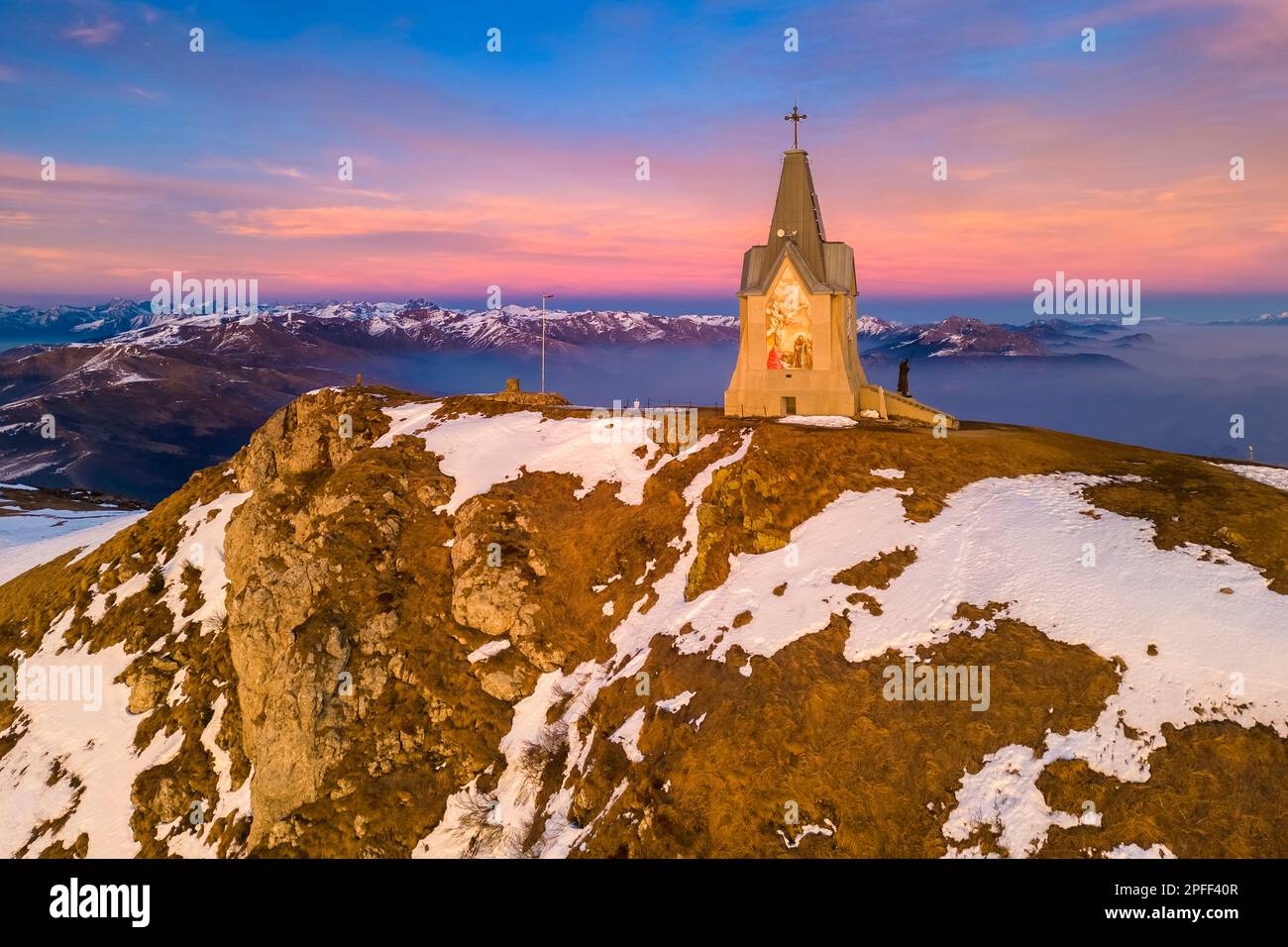 Veduta aerea di un tramonto invernale sulla cappella del Monumento al Redentore sulla cima del Monte Guglielmo. Zona, provincia di Brescia, Lombardia, Italia. Foto Stock