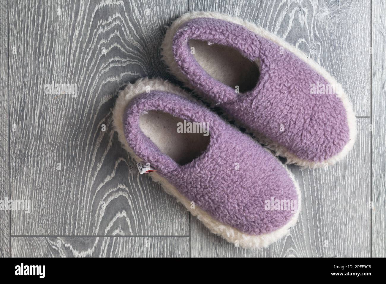 Un paio di pantofole in lana sono collocate sul pavimento in legno grigio e offrono vista dall'alto Foto Stock