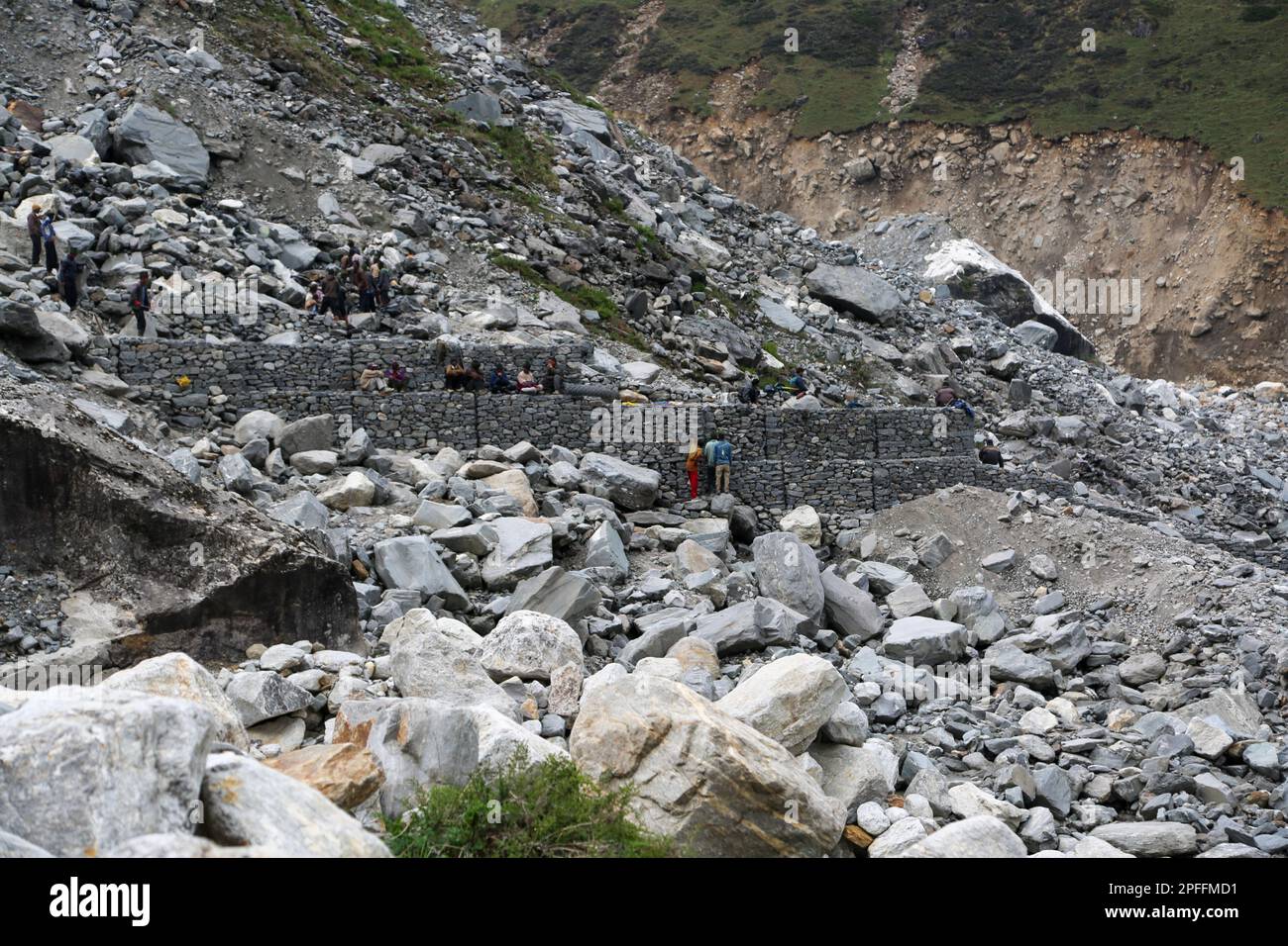 Rudarprayag, Uttarakhand, India, giugno 17 2014, Laborer costruzione muro di sicurezza dopo il disastro di Kedarnath. Kedarnath fu devastato il 2013 giugno a causa della terra Foto Stock