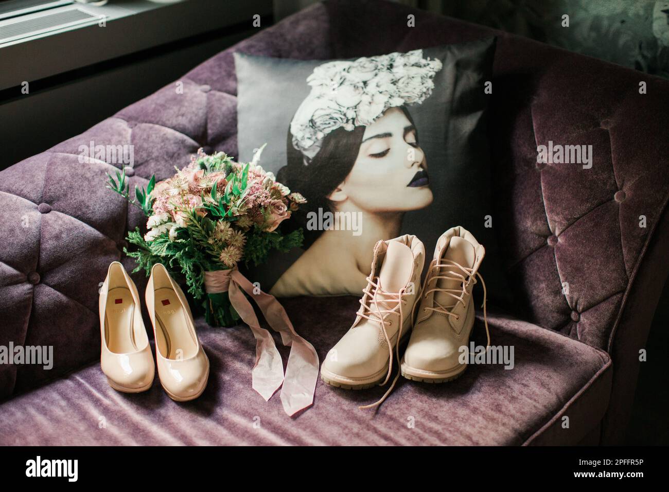 Fiori per matrimoni, stivali e tacchi sulla pupilla soffrono di velluto con un bellissimo cuscino vicino. Foto Stock
