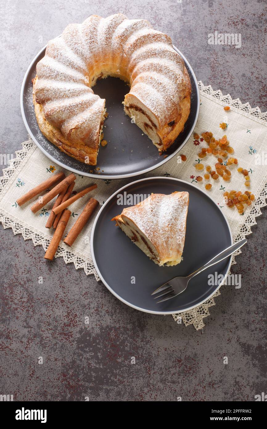 Festa torta di reindling con uva passa e cannella primo piano in un piatto sul tavolo. Vista verticale dall'alto Foto Stock