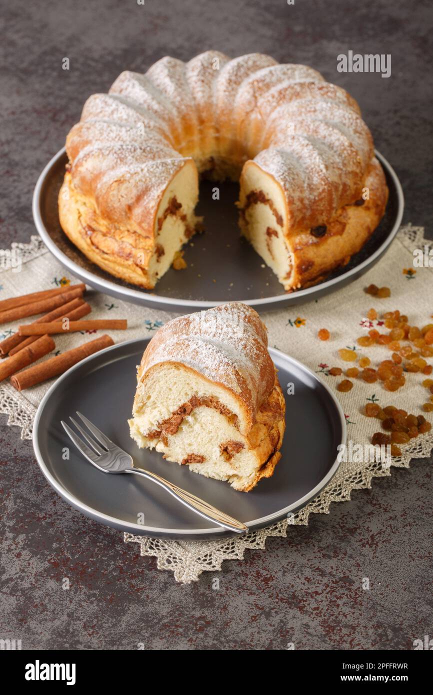 Festa torta di reindling con uva passa e cannella primo piano in un piatto sul tavolo. Verticale Foto Stock