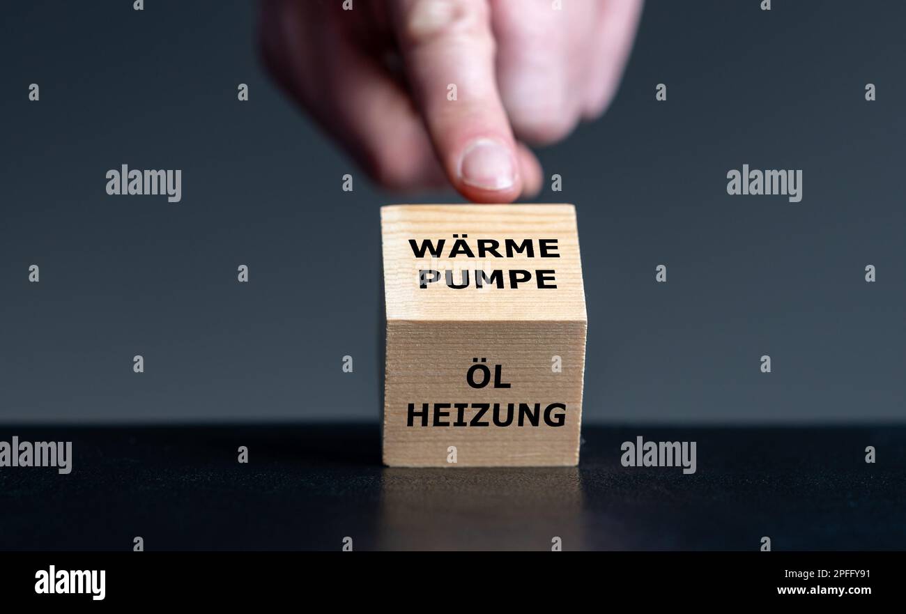 Simbolo per il divieto di impianti privati di riscaldamento ad olio in Germania. La mano gira il cubo e cambia l'espressione tedesca 'Oelheizung' (riscaldamento ad olio) in 'Waermep Foto Stock