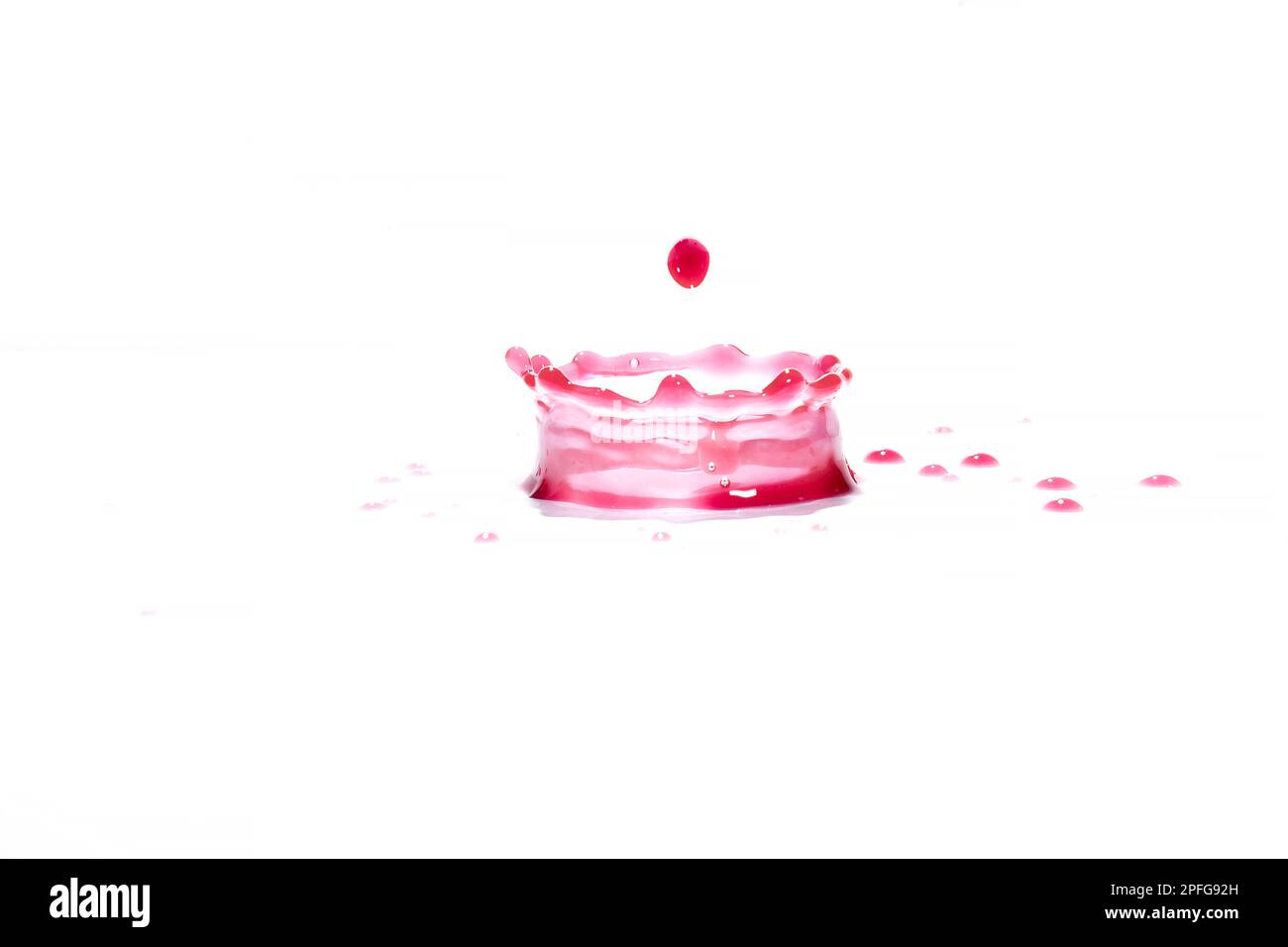 Spruzzi di acqua rossa su sfondo bianco, fotografia. Spruzzi d'acqua rossi. Foto Stock