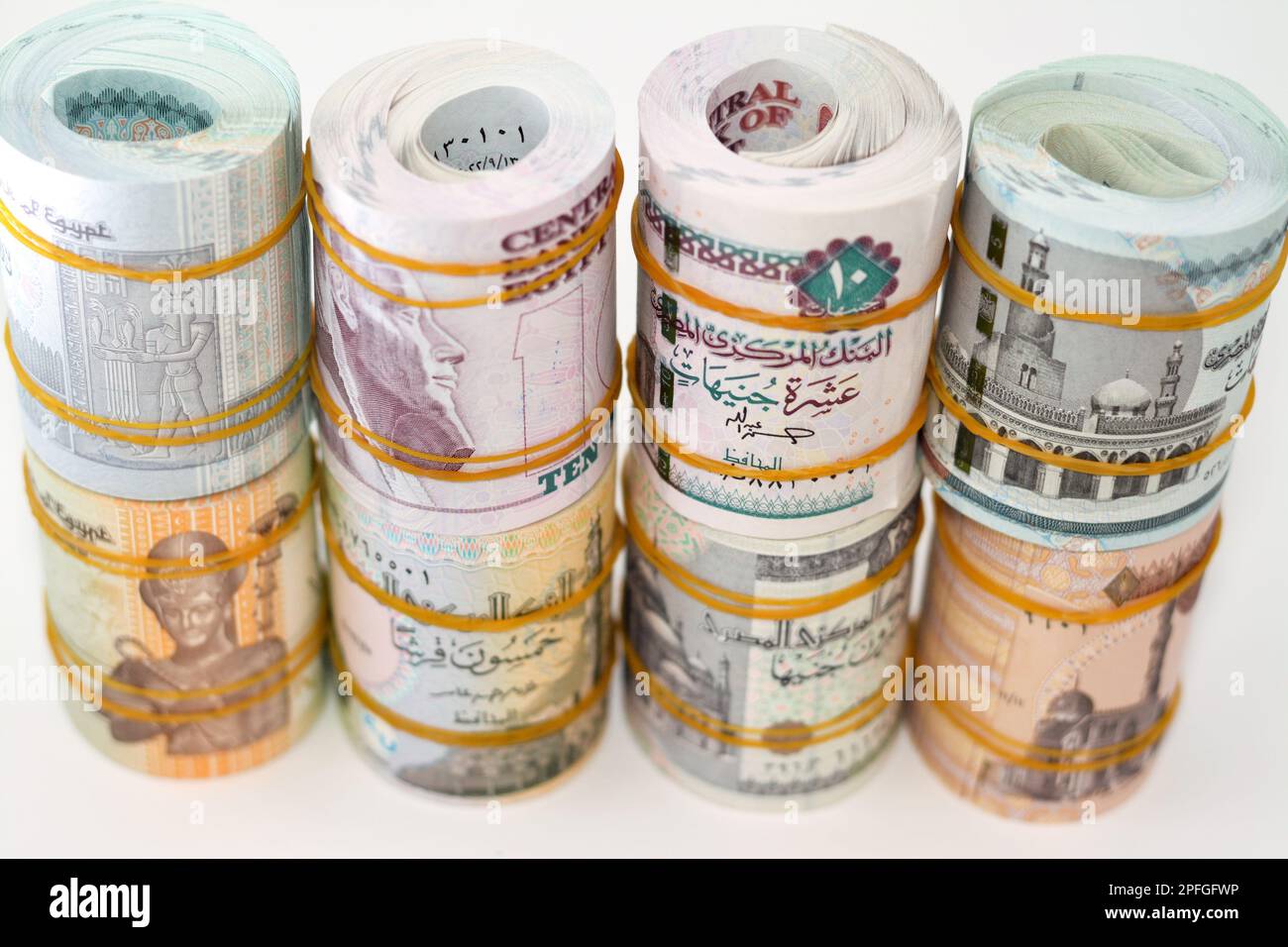 Contesto di pacchetti e rotoli di banconote in moneta egiziana arrotolate con fasce di gomma in diversi valori di fattura di 1 LE, 5, 10, 20 EGP Foto Stock