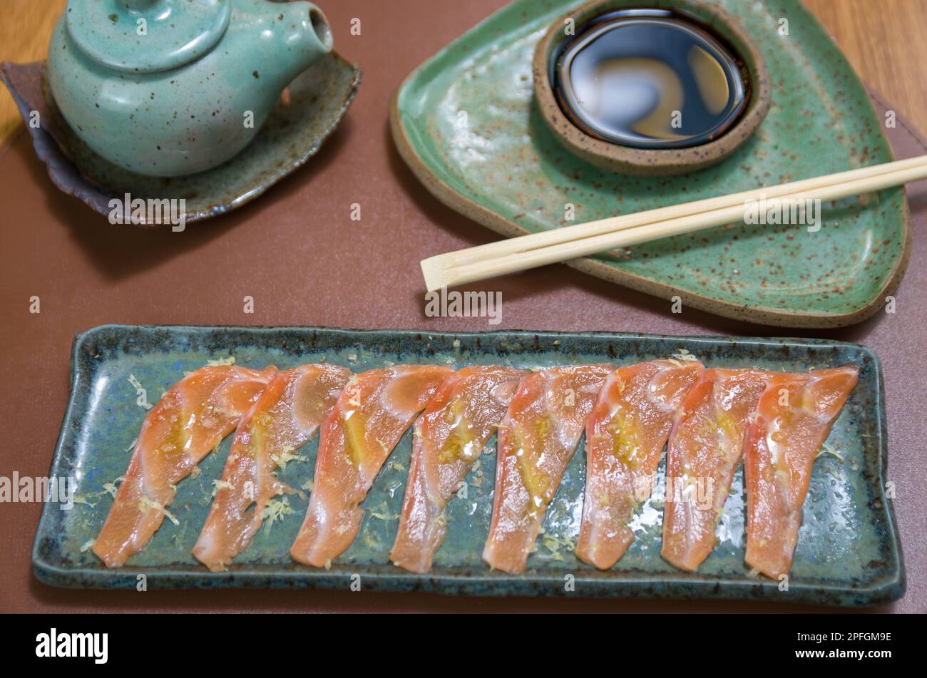 Deliziosi sashimi di salmone di prima qualità disposti su un elegante piatto fatto a mano. Foto Stock