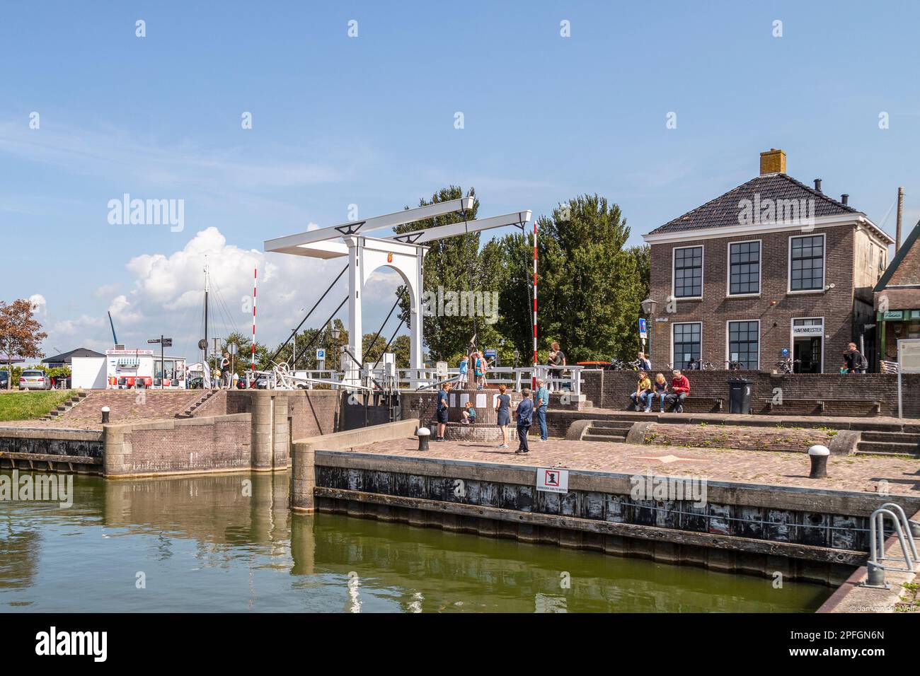 Persone lungo la banchina con il ponte levatoio bianco nel centro del pittoresco villaggio di pescatori di Stavoren, sull'IJsselmeer. Foto Stock