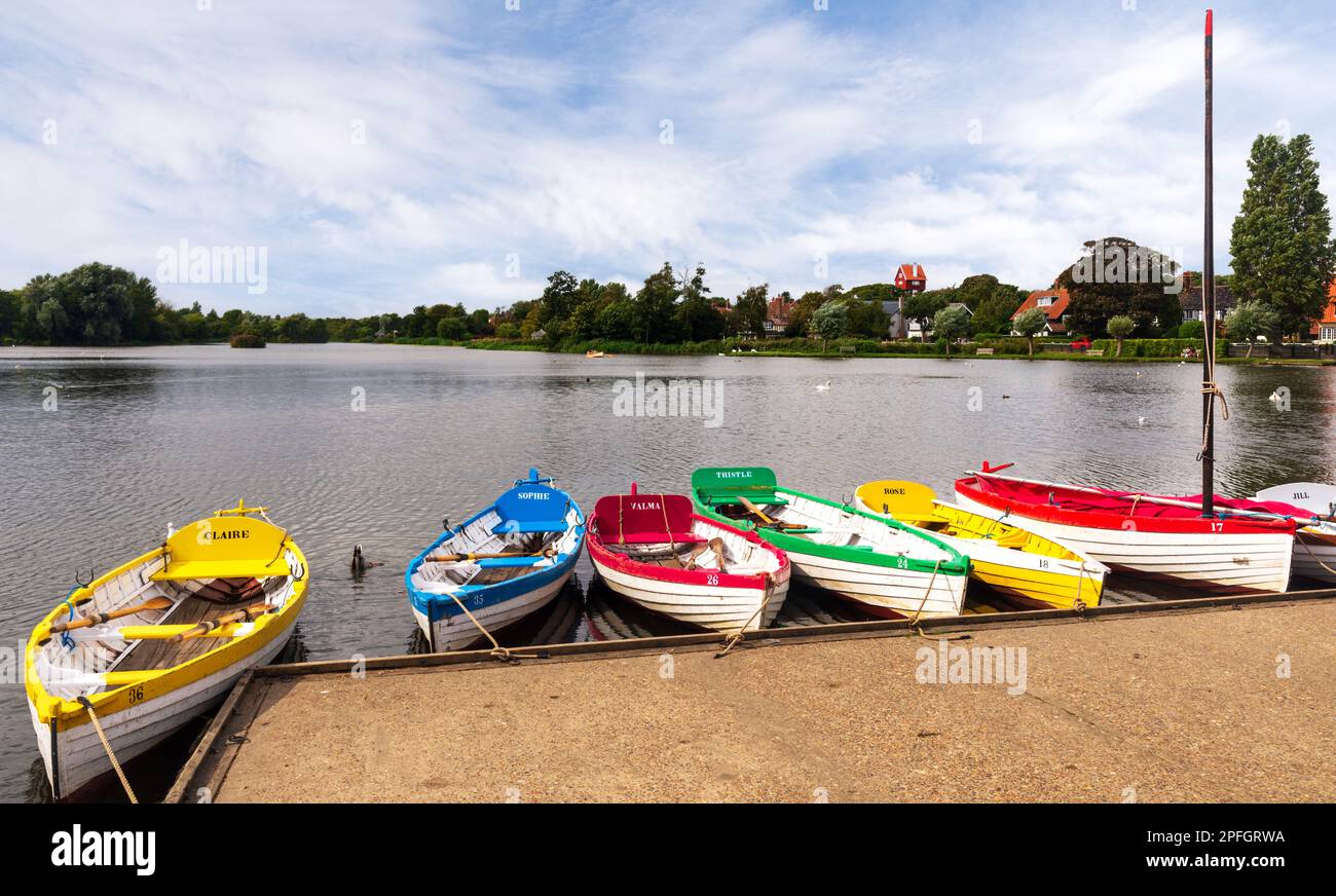 Paesaggio di Thorpeness Mere che mostra barche a remi dai colori vivaci che sono a noleggio Foto Stock