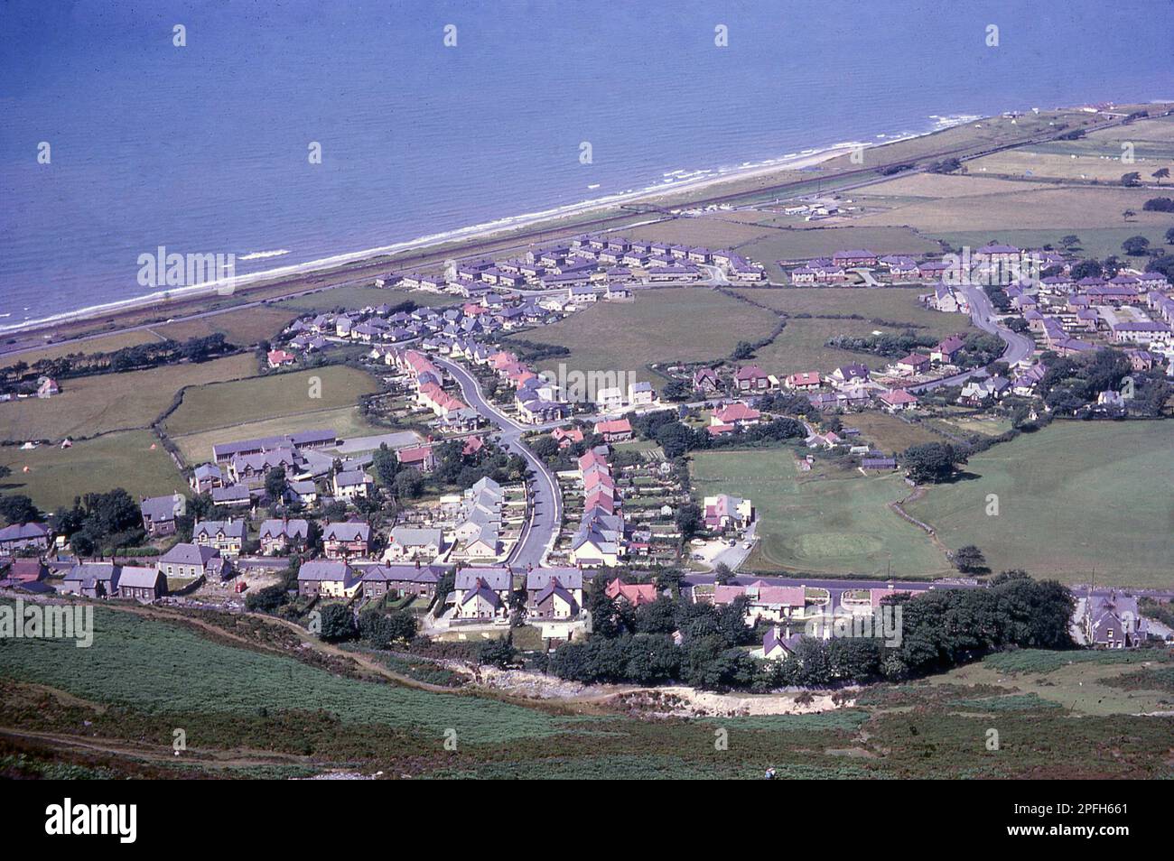 1964, storico, vista aerea sulla città costiera di Penmaenmawr, Conwy, Galles, come visto dalla montagna alta, che la città prende il nome. Foto Stock