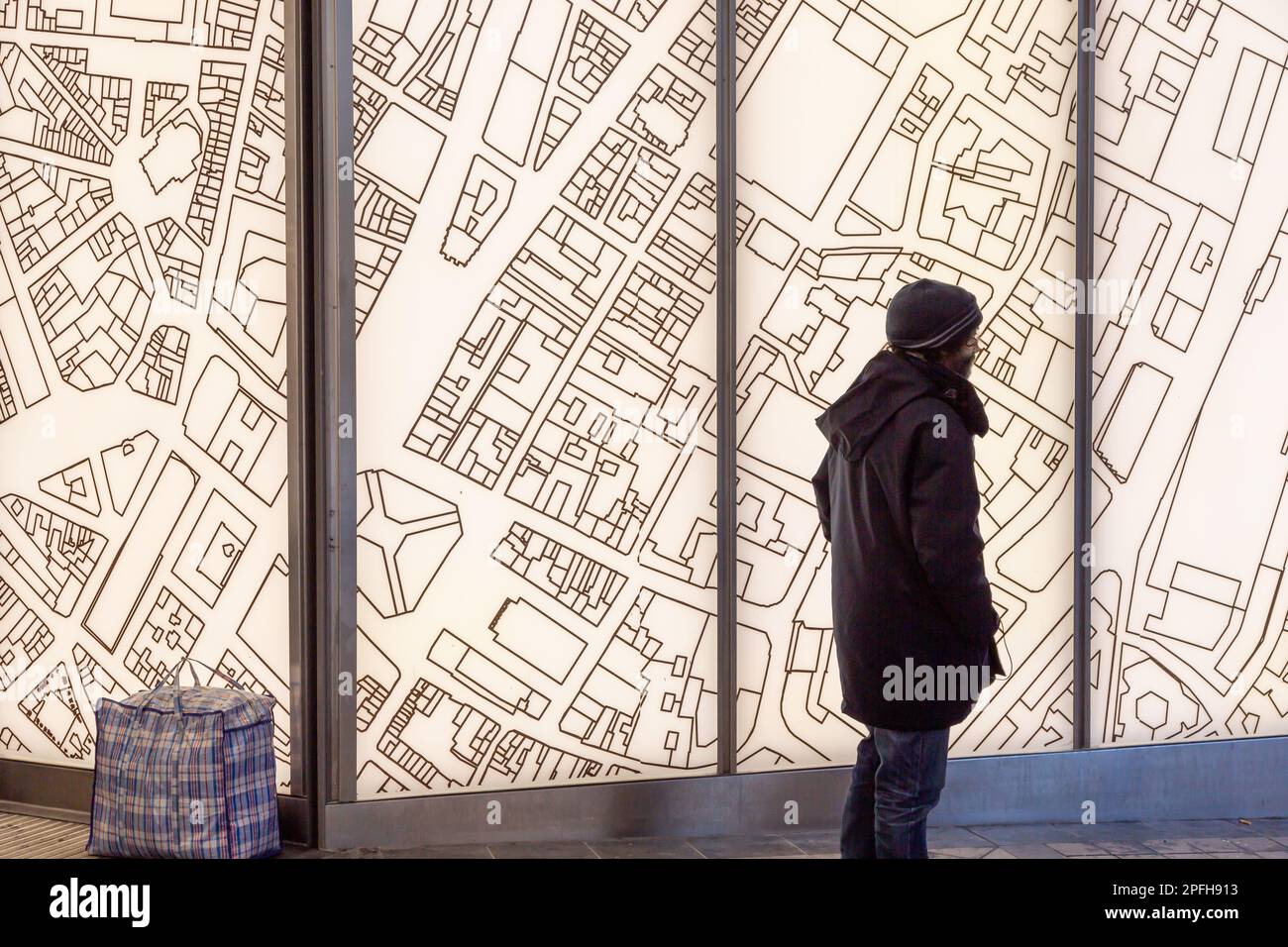 Sagoma di un uomo che si trova di fronte a una mappa retroilluminata della città di Bruxelles. Foto Stock