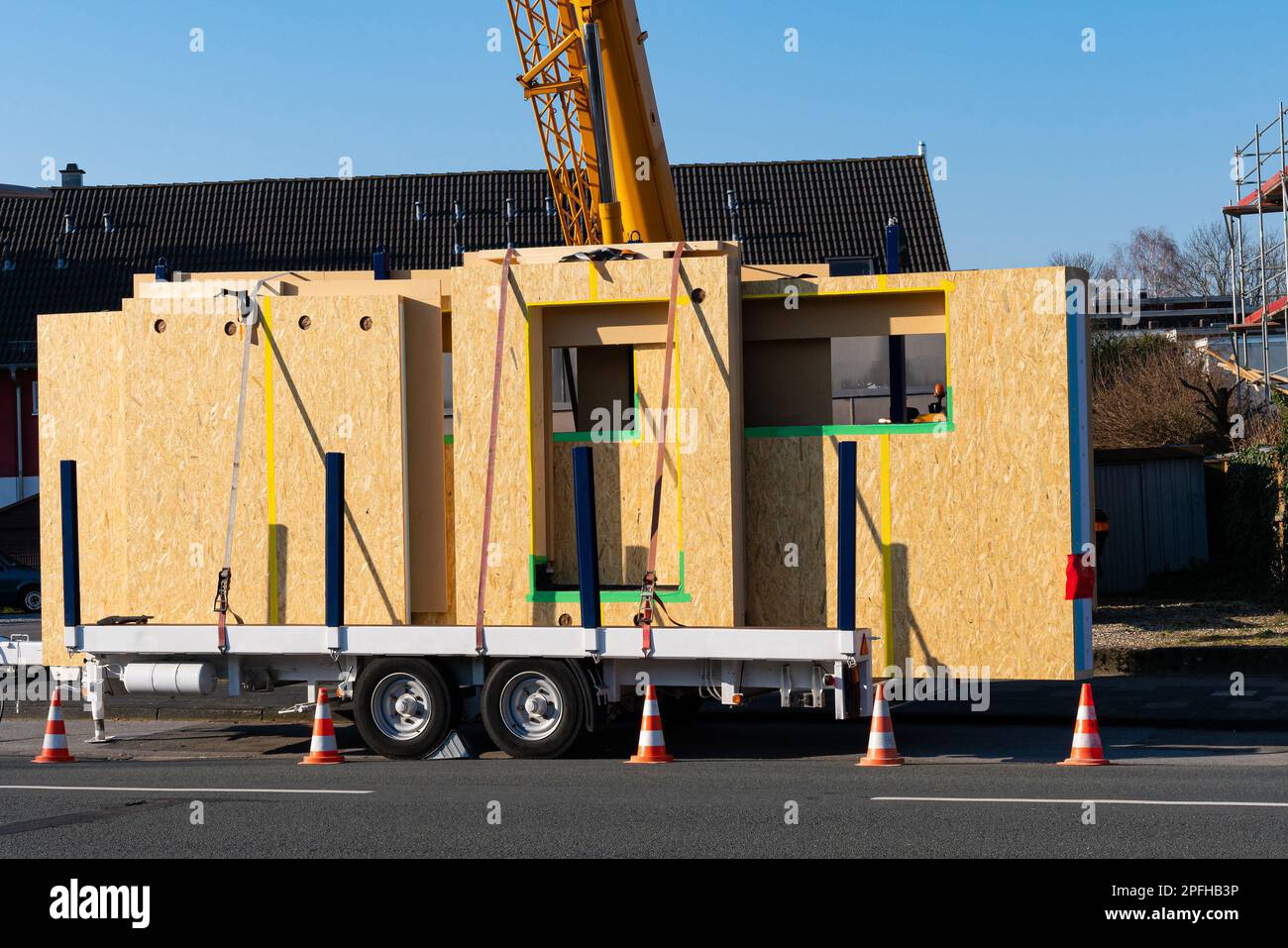 Pronto per lo scarico di pannelli di una casa prefabbricata in legno. Braccio della gru sul retro. Rimorchio per auto. Foto Stock