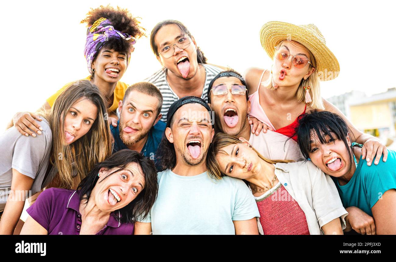 Multiculturale persone di età mista prendere selfie uscire lingua facendo volti divertenti - Crazy stile di vita e concetto di integrazione Foto Stock