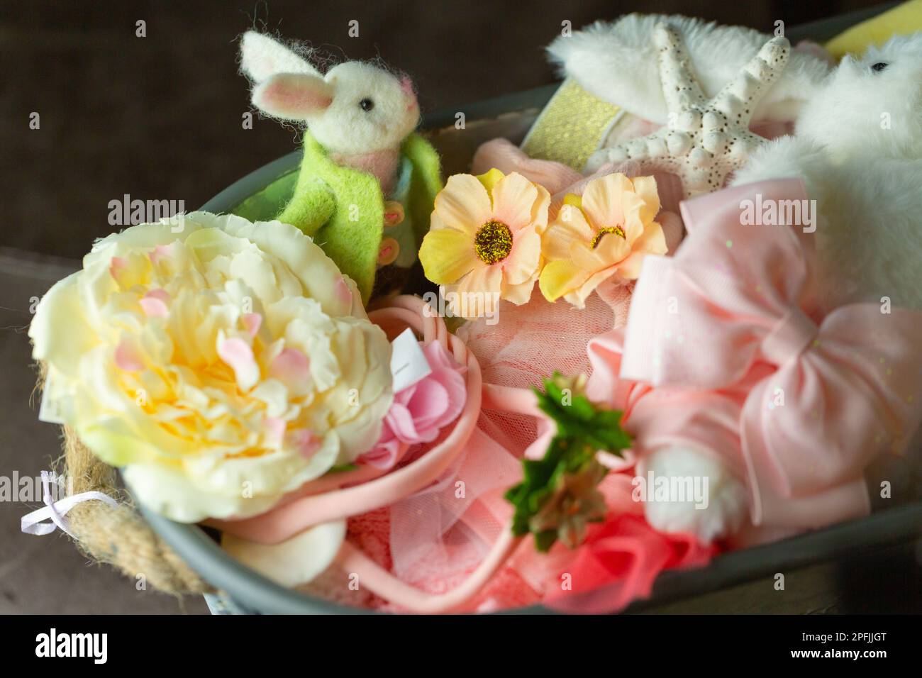 Primo piano di un coniglietto pasquale in feltro e vestiti e oggetti colorati in un contenitore. Foto Stock