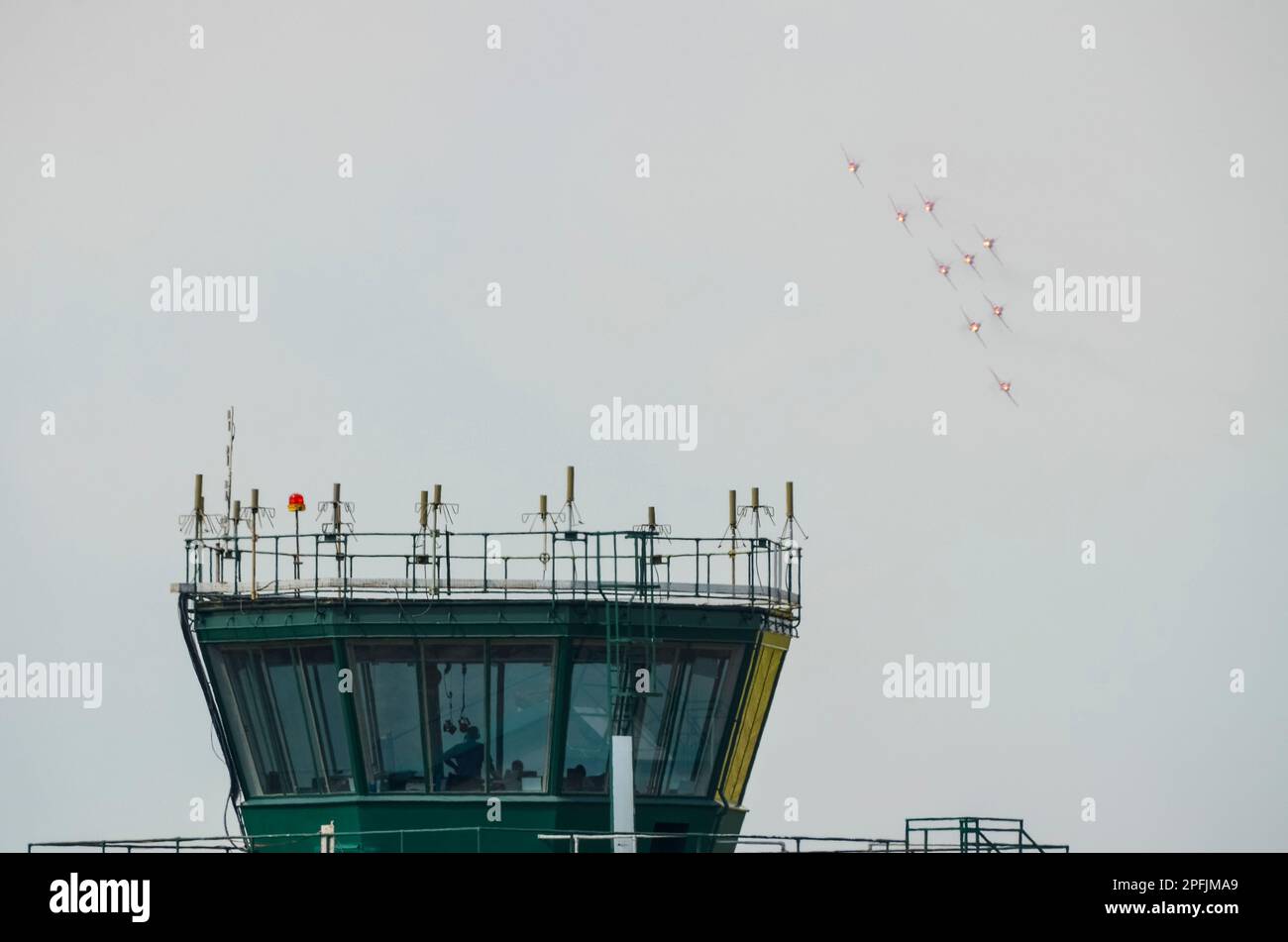 Royal Air Force Red Arrows mostra il team BAe Hawk T1 aerei a reazione che espongono al RAF Scampton, sopra la torre di controllo del traffico aereo. Guarda l'ufficio Foto Stock