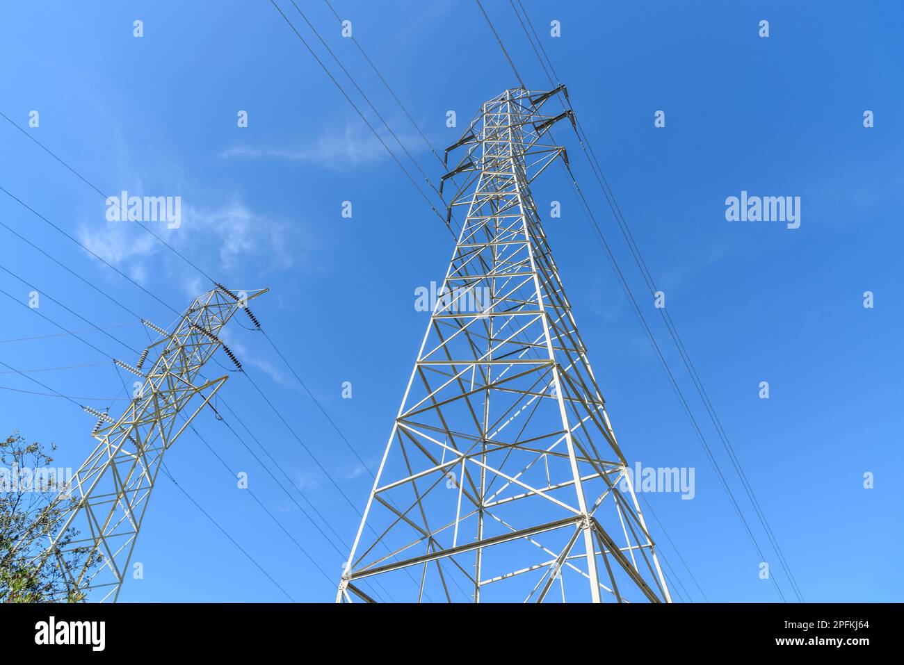 Piloni elettrici ad alta tensione sotto il cielo limpido in autunno Foto Stock