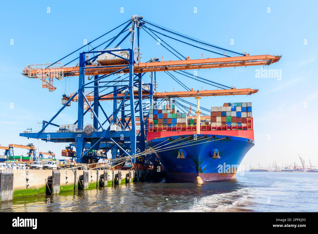Grande nave portacontainer caricata in un porto in una giornata estiva di sole Foto Stock