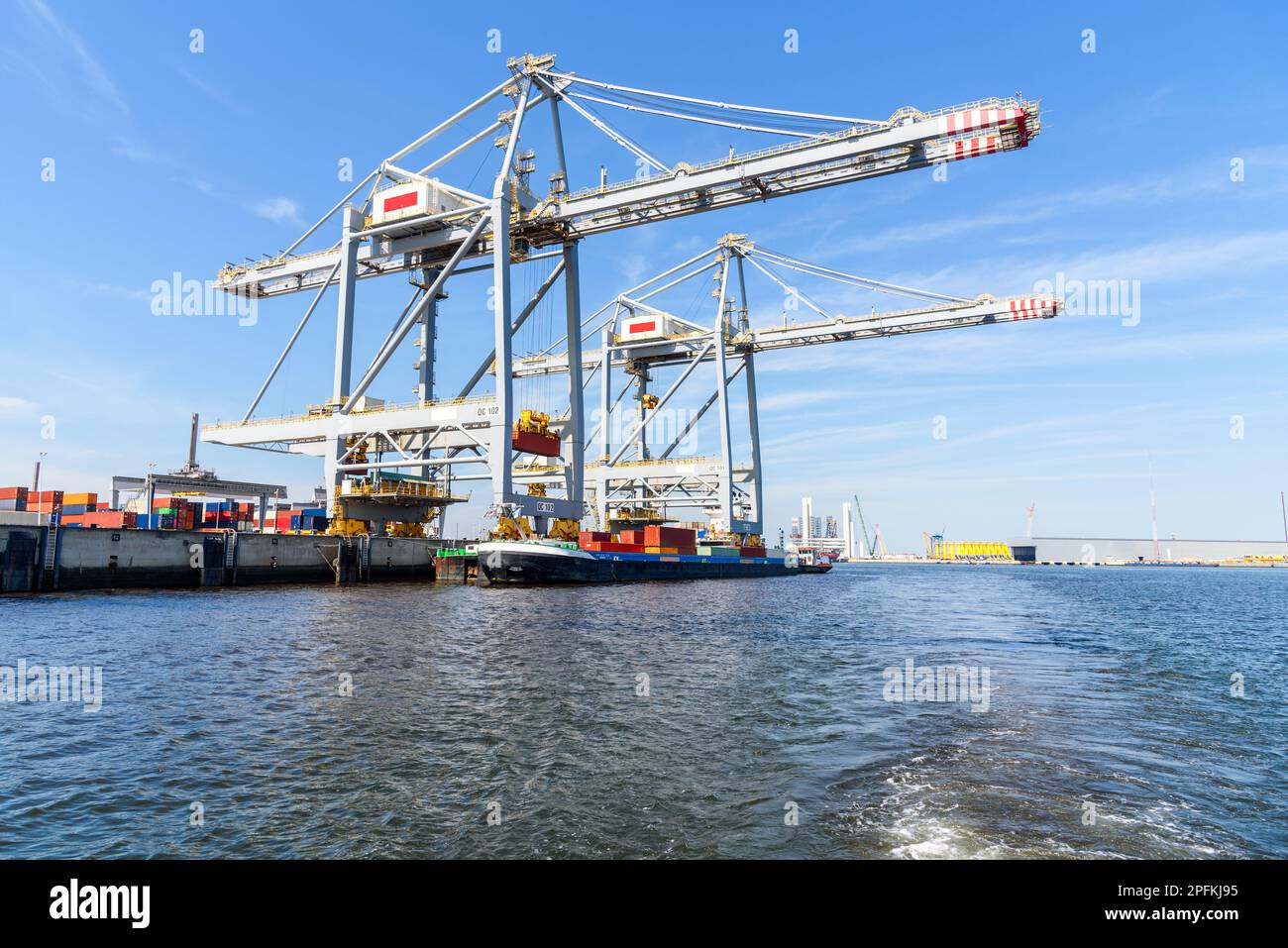 Chiatta di carico che è caricata con i contenitori in un porto in una giornata di estate di sole Foto Stock