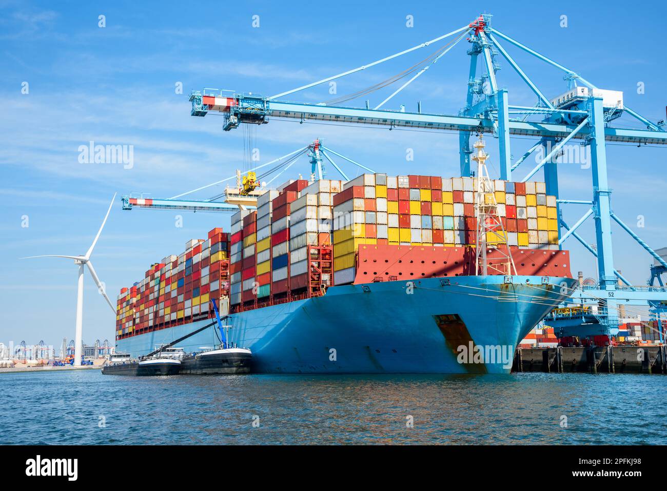 Grande nave da carico piena di container ancorati a un terminal container in una giornata estiva di sole Foto Stock