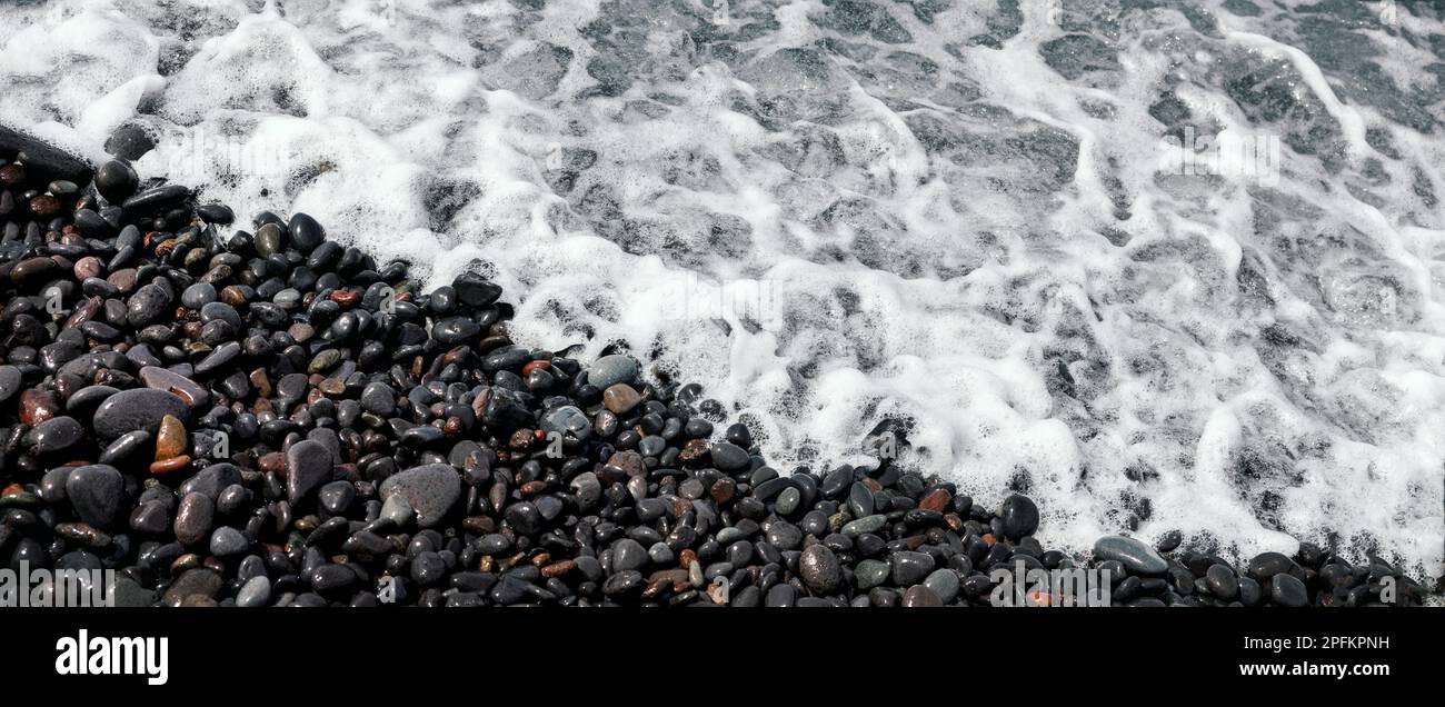 spiaggia rocciosa. ciottoli lavati dalle onde. banner con spazio di copia Foto Stock