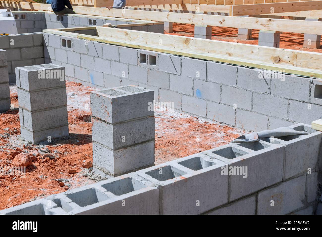 La casa di costruzione comincia sul luogo di costruzione con l'installazione della fondazione dei blocchi di cemento Foto Stock