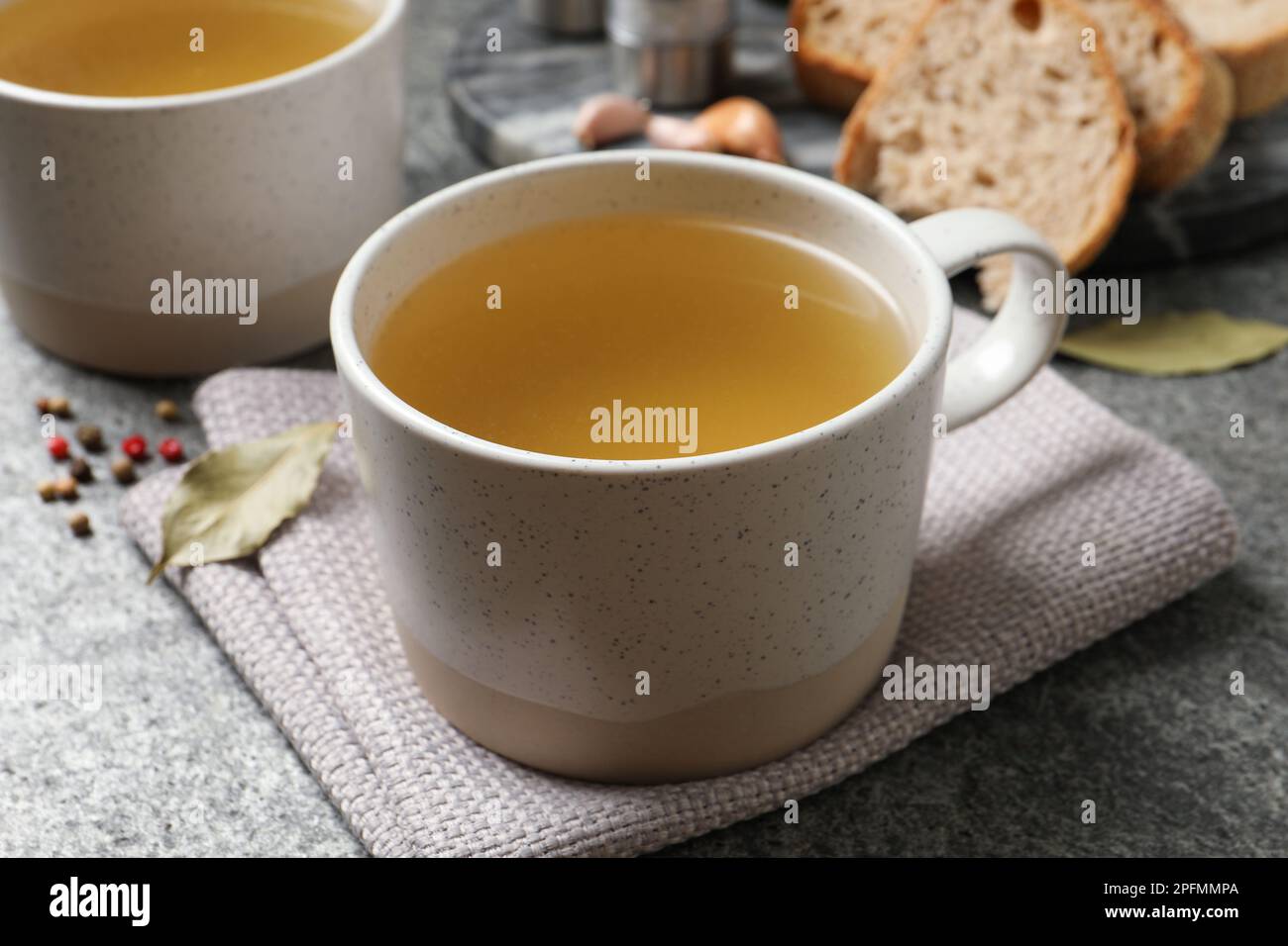 Delizioso bouillon caldo in tazze sul tavolo grigio Foto Stock