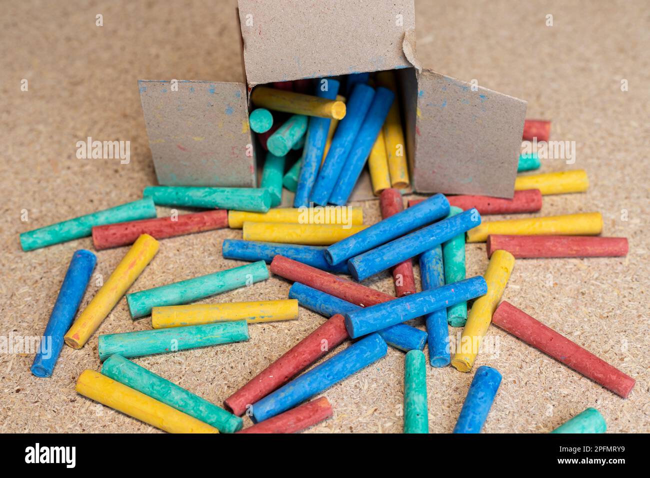 Gessi colorati sparsi in una scatola su una scrivania Foto Stock