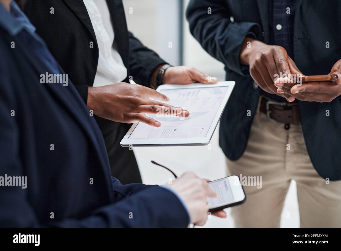 Gestione del rischio semplificata con le app intelligenti. un gruppo di uomini d'affari che utilizzano dispositivi wireless durante una riunione in un ufficio moderno. Foto Stock