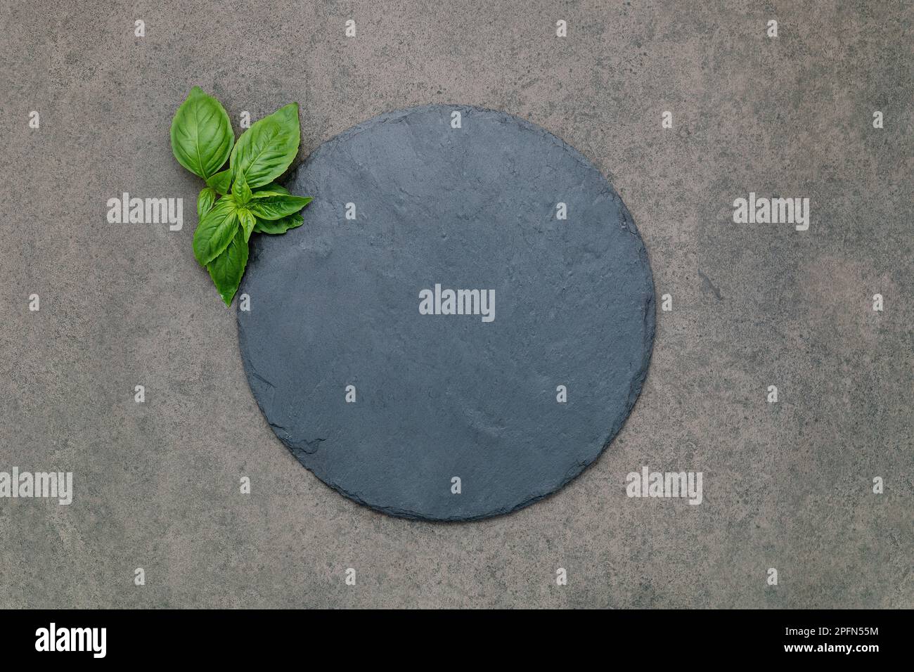 Piatto di pizza vuoto per cottura fatta in casa su cemento scuro. Concetto di ricetta alimentare su sfondo di pietra scura con spazio di copia. Foto Stock
