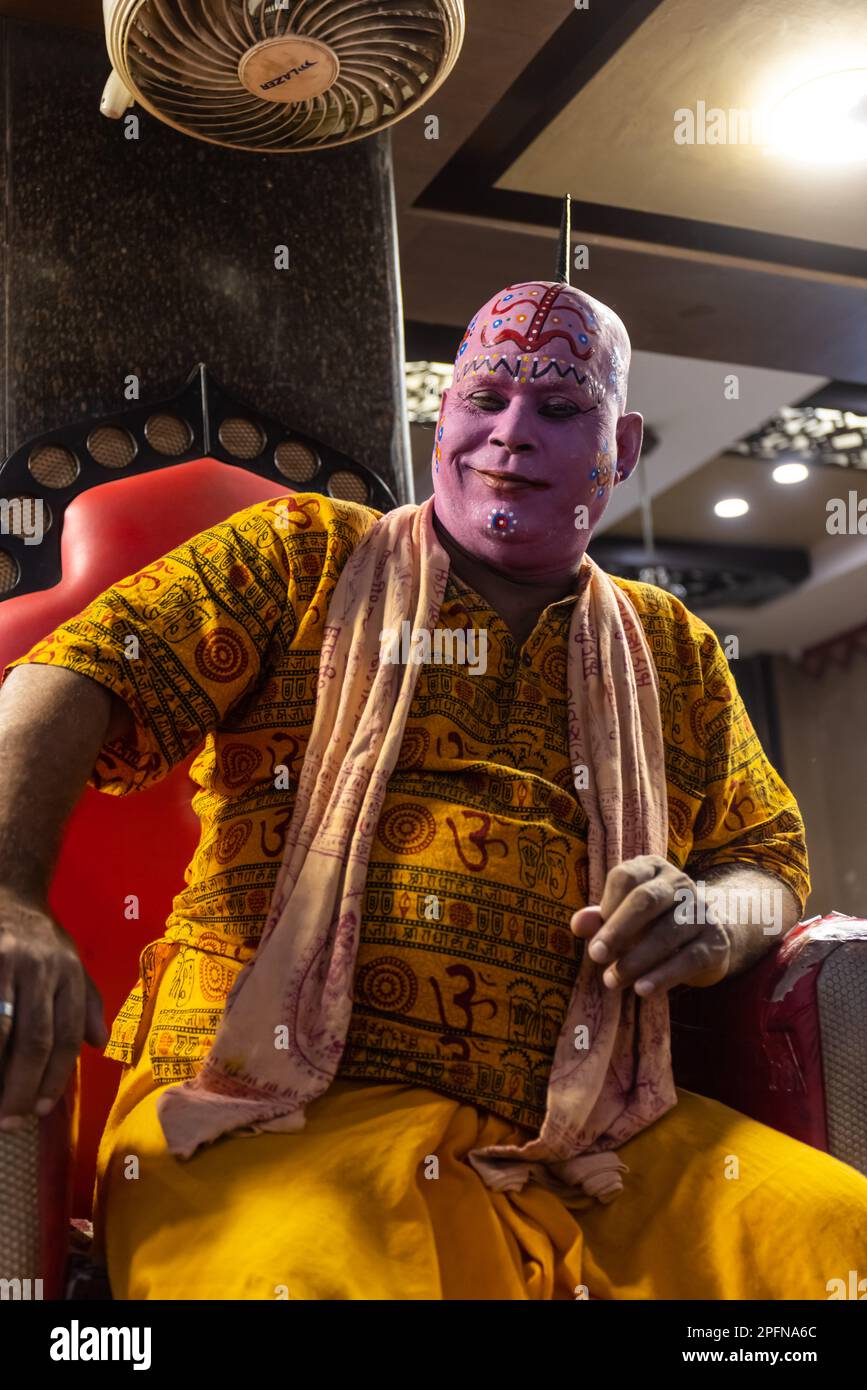 Ritratto di un maschio con volto dipinto seduto in un famoso negozio chiamato Choti Wala a rishikesh. Messa a fuoco selettiva di notte. Foto Stock