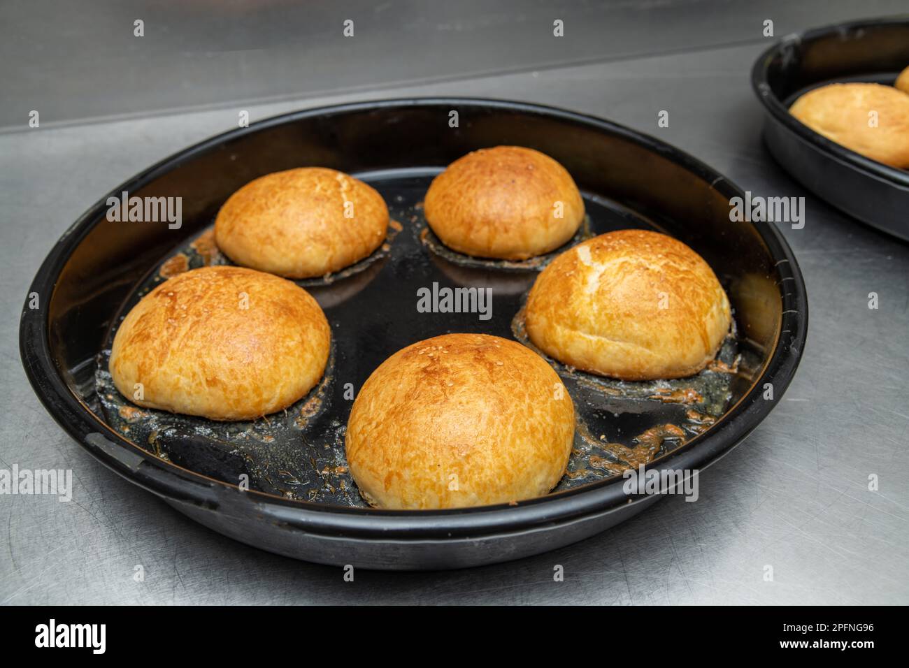 Hamburger panini caldi appena sfornati in un forno industriale Foto Stock