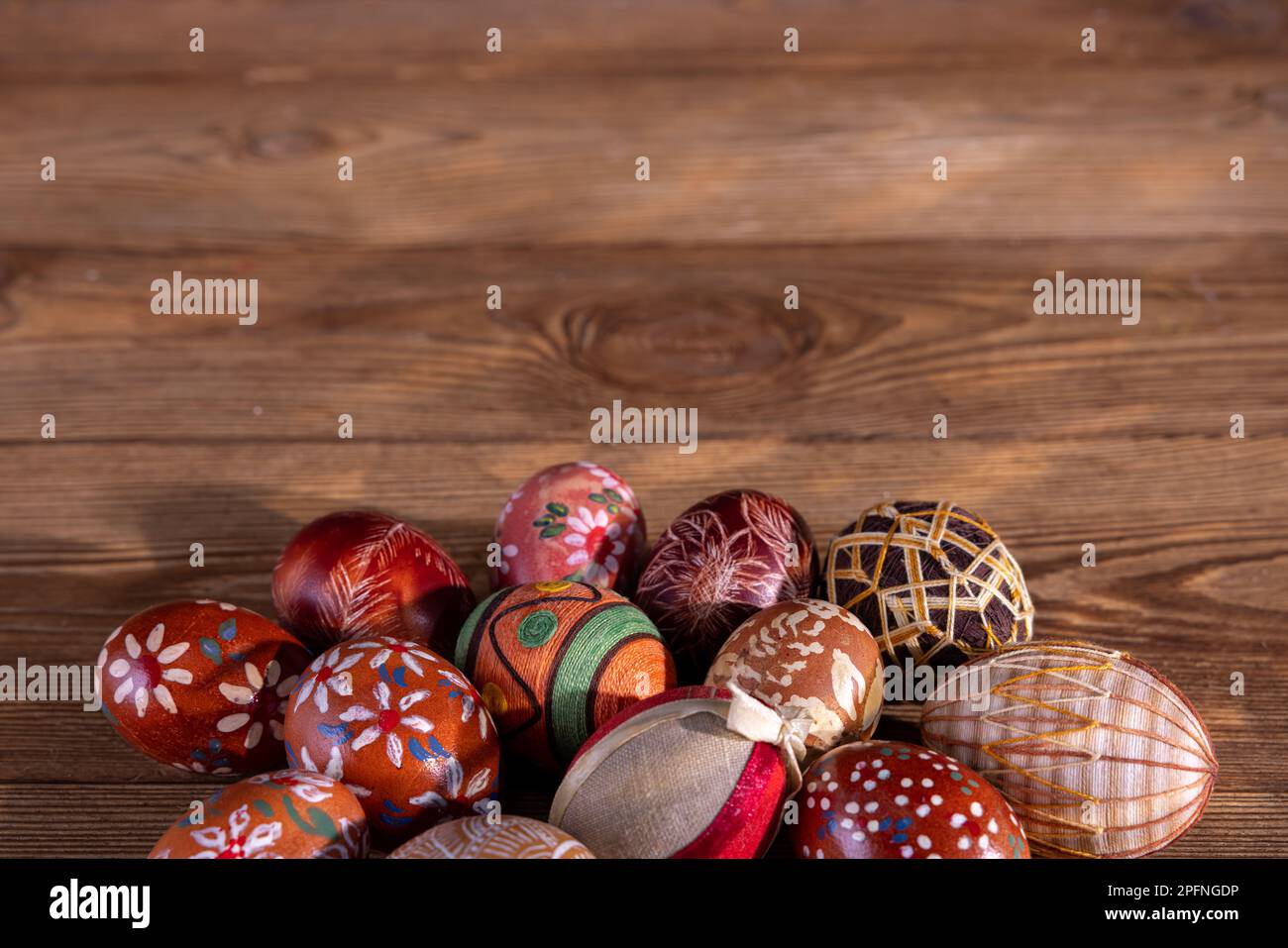 Una collezione di uova di Pasqua con colori marroni giacenti su vecchie tavole. Foto Stock