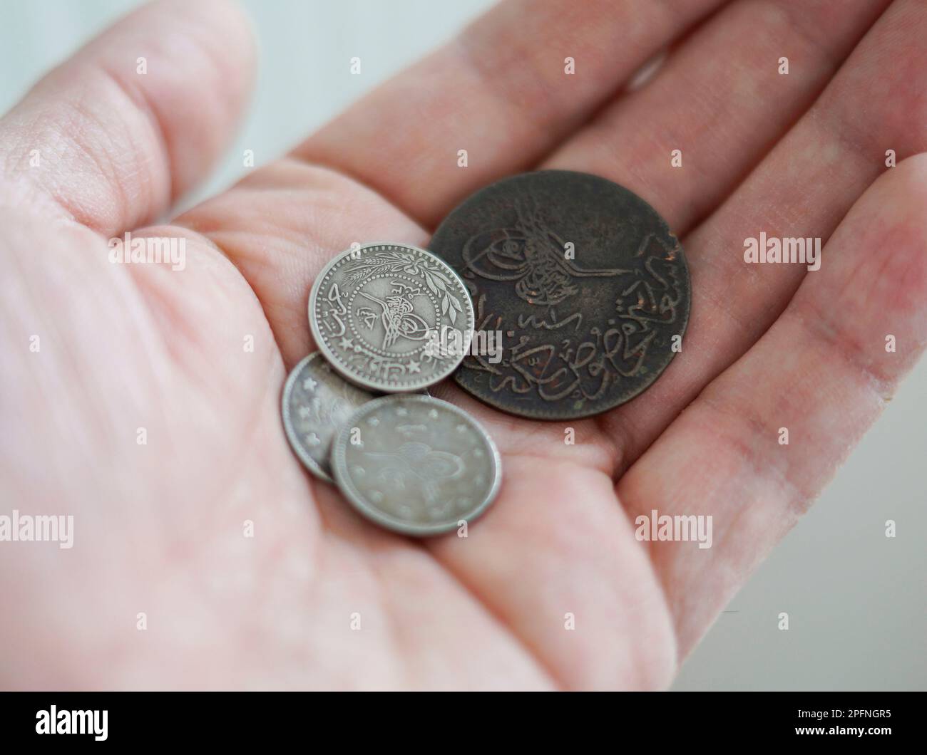 Antiche monete d'argento e rame dell'Impero Ottomano. Uomo che tiene in mano Foto Stock