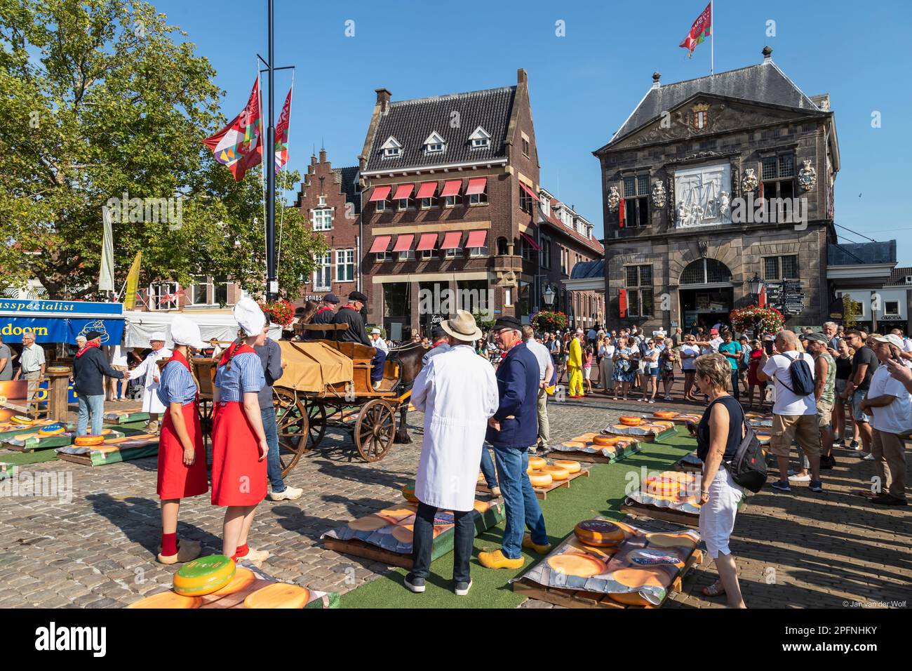 Cavallo e carrozza, ragazze di formaggio, commercianti e turisti al mercato del formaggio nella città olandese del formaggio di Gouda. Foto Stock