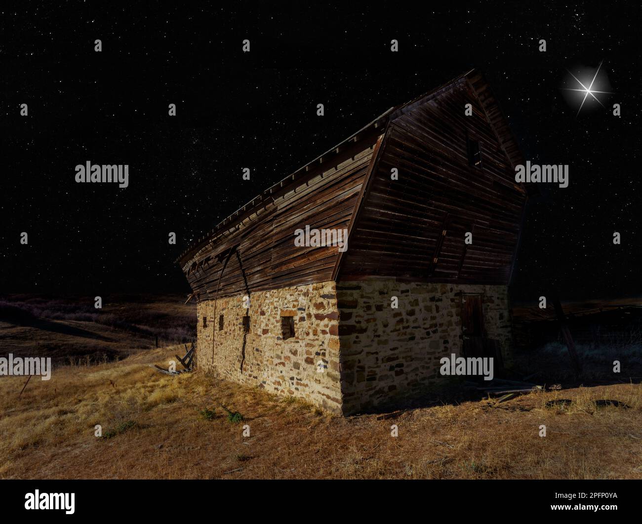 Stella luminosa bassa su un vecchio fienile in una notte stellata Foto Stock