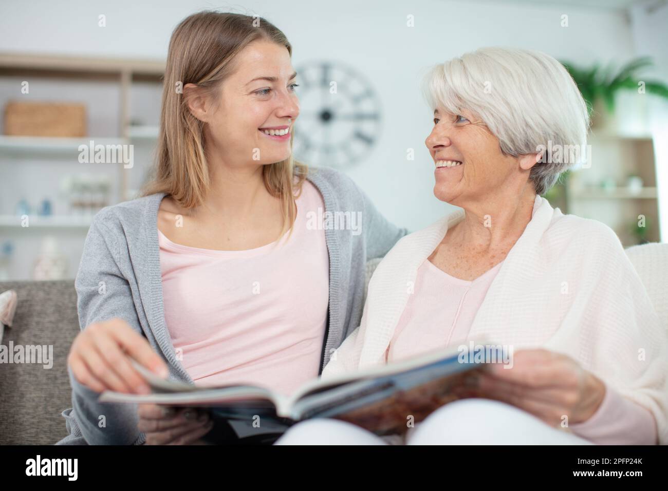 madre e figlia guardando foto libro due donne a casa Foto Stock