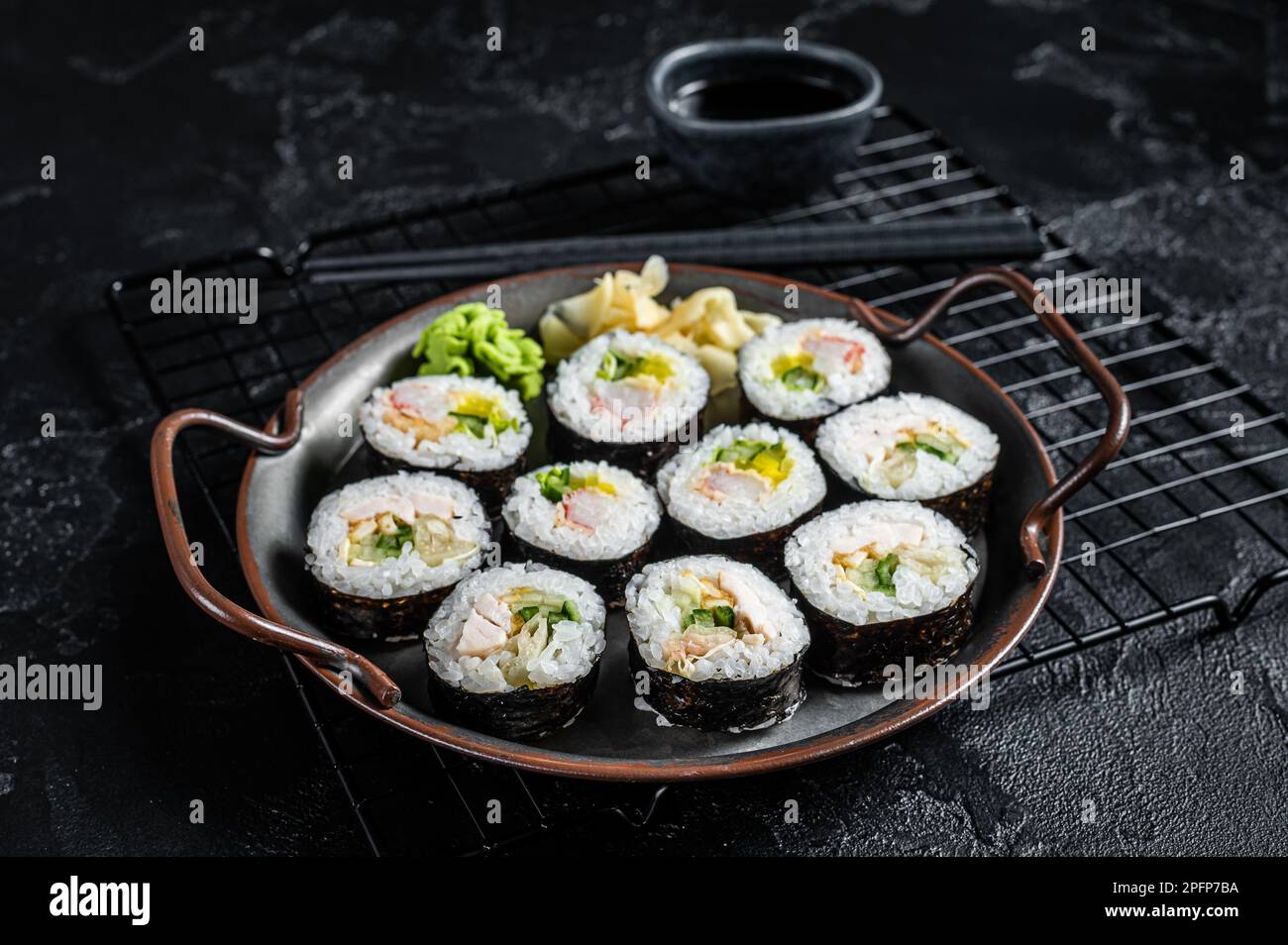 Gimbap Kimbap ripieno di verdure, uova, acciughe e granchio, rotolo di riso coreano. Sfondo nero. Vista dall'alto. Foto Stock