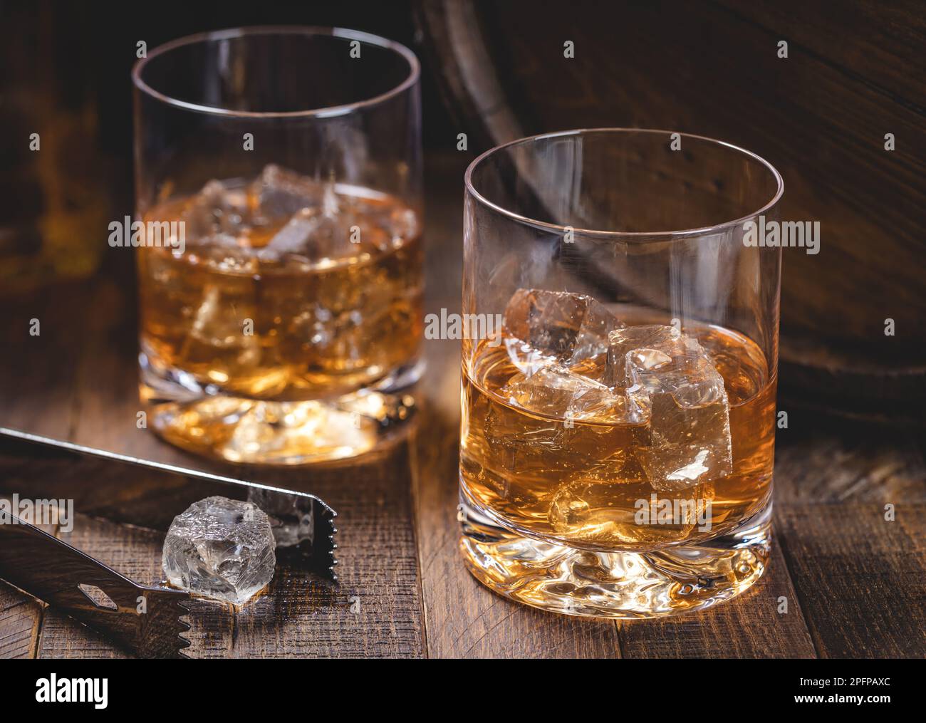 Due bicchieri di whisky con ghiaccio su un rustico sfondo di legno Foto Stock