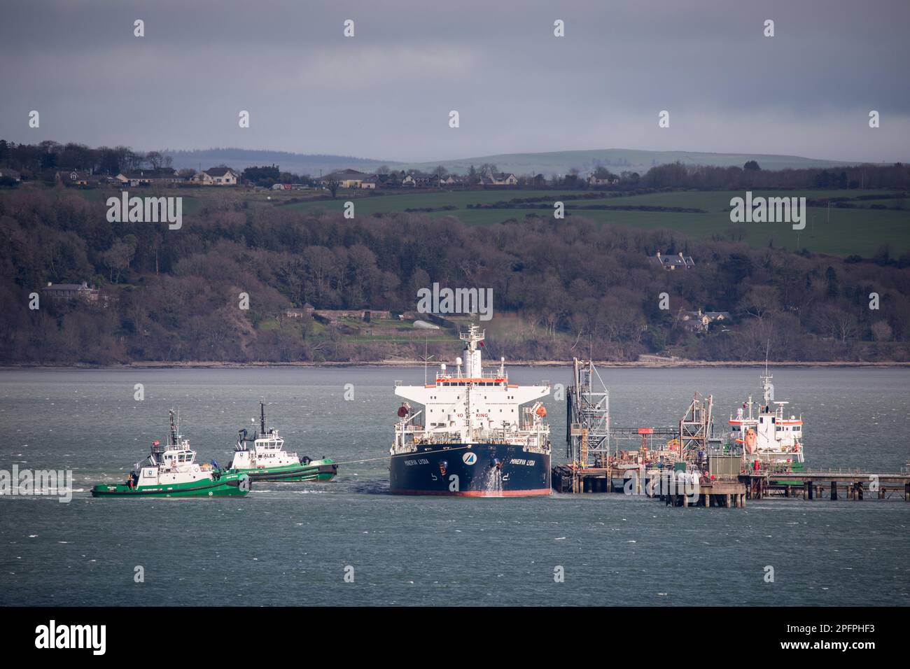 WhiteGate, Cork, Irlanda. 18th marzo, 2023. Le barche da traino DSG Titan e Alex trainano la petroliera Minerva Lydia dal molo della raffineria di WhiteGate, Co. Cork, Irlanda. - Credit; David Creedon / Alamy Live News Foto Stock