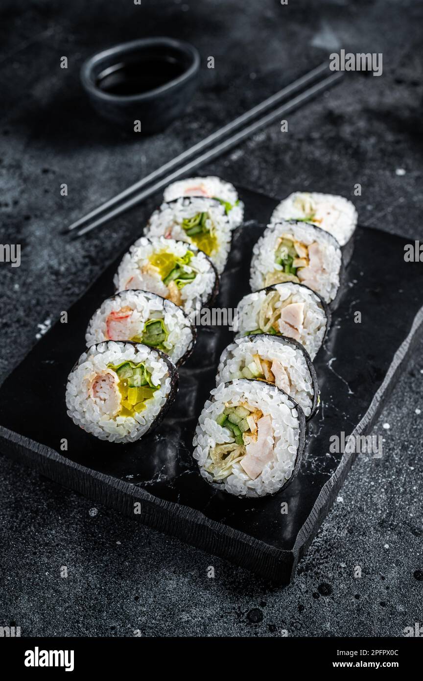 Rotolo di riso coreano Kimbap o gimbap, sushi coreano. Sfondo nero. Vista dall'alto. Foto Stock