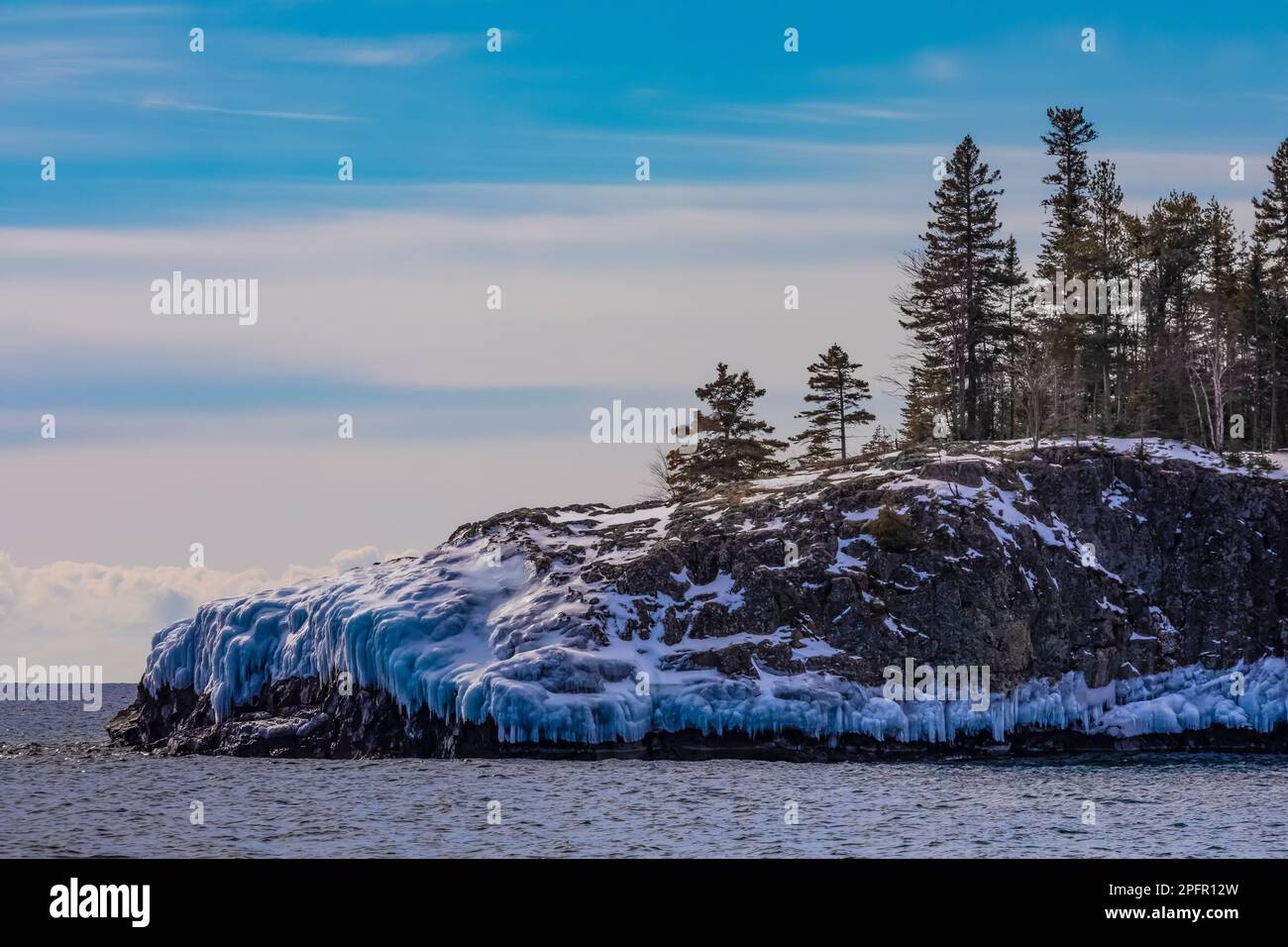 Spiaggia rocciosa con ghiaccio dalle onde recenti, parco statale del faro di Split Rock sul lago Superior, Minnesota, USA Foto Stock