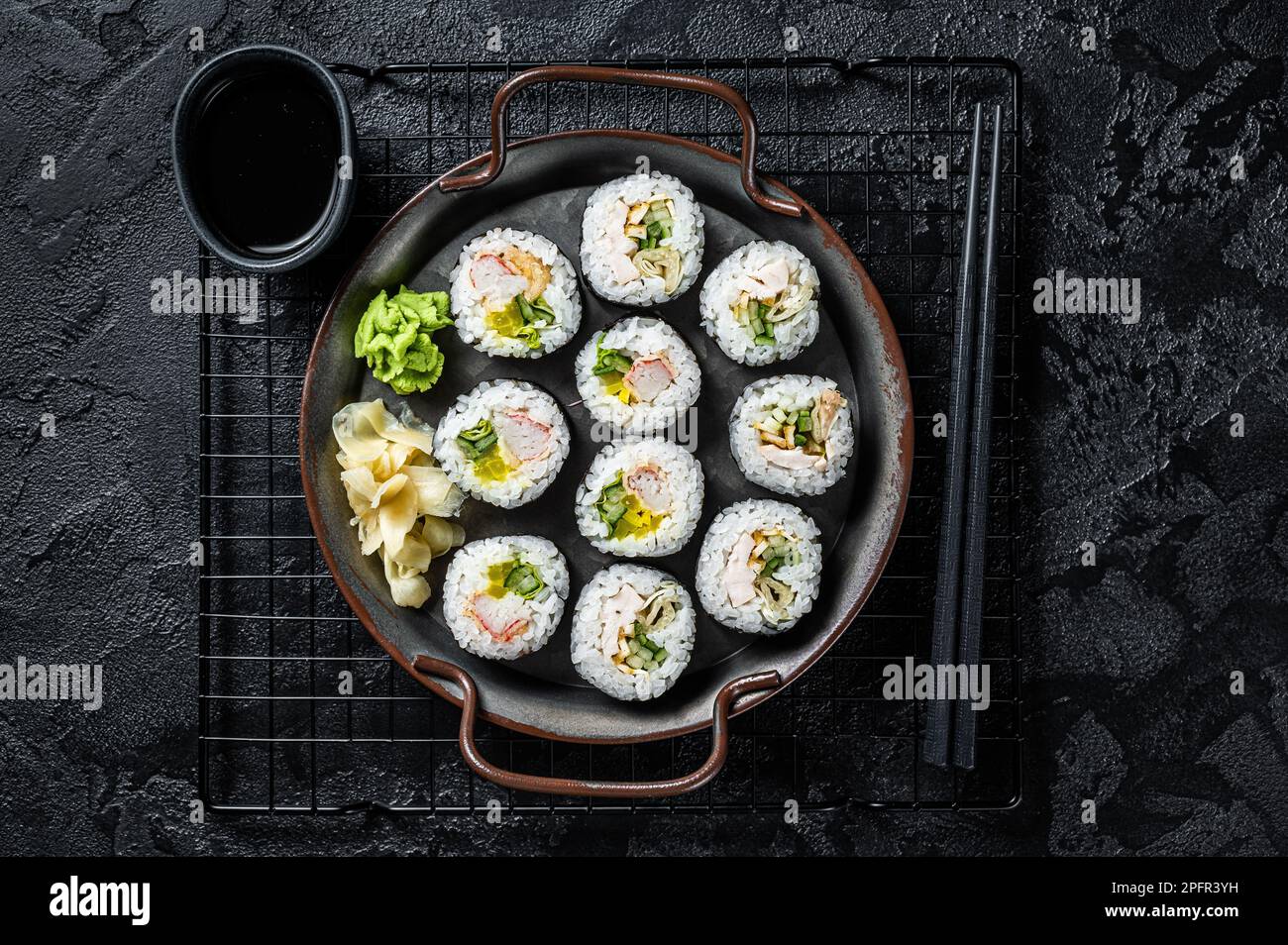 Gimbap Kimbap ripieno di verdure, uova, acciughe e granchio, rotolo di riso coreano. Sfondo nero. Vista dall'alto. Foto Stock