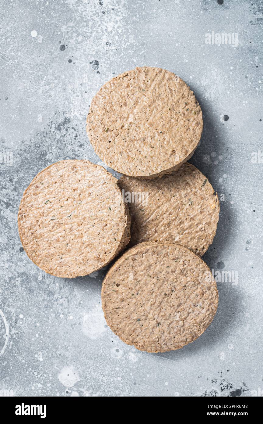 Carne cruda polpettine di hamburger a base di piante libere, cotolette vegetariane. Sfondo grigio. Vista dall'alto. Foto Stock